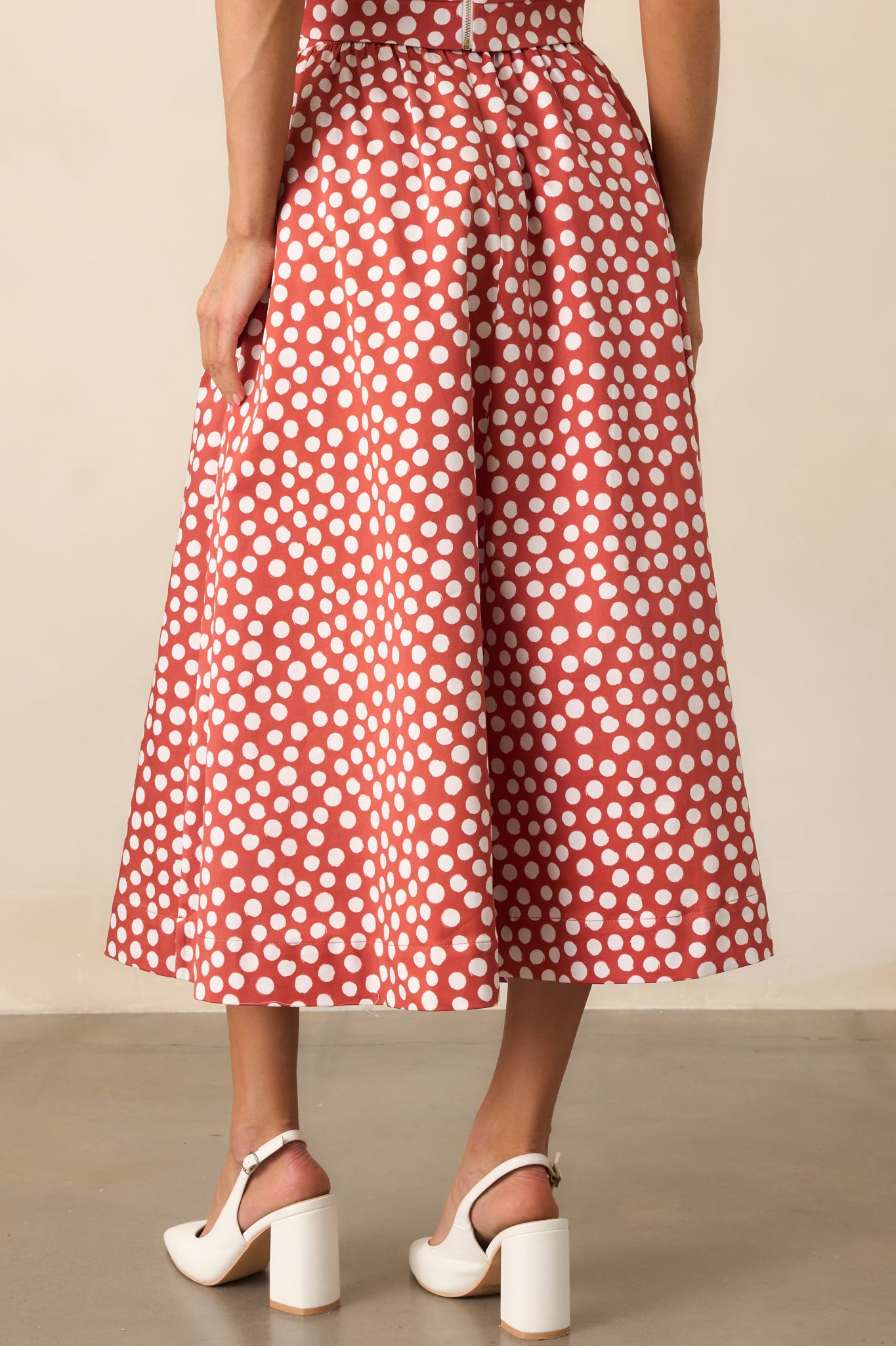 Rear view of the brick red midi skirt with white polka dots and elastic waist insert.