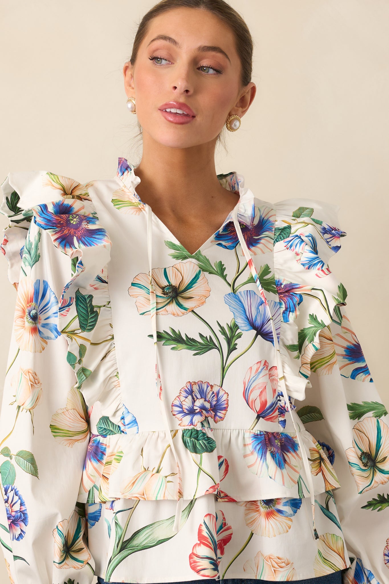 Cropped view of the ruffle accents and multicolor pattern on the ivory fabric.