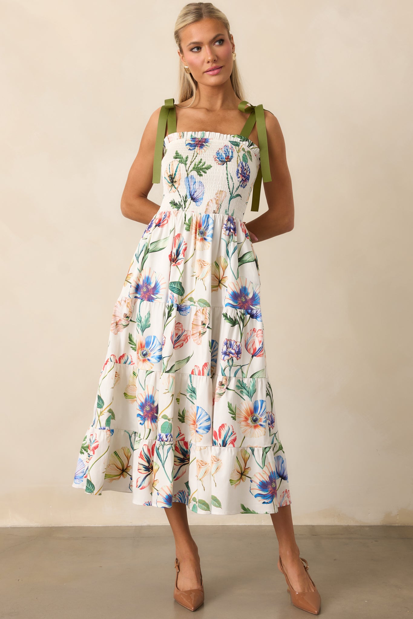 Ivory floral midi dress with smocked bodice, flowing tiers, and colorful print accents.