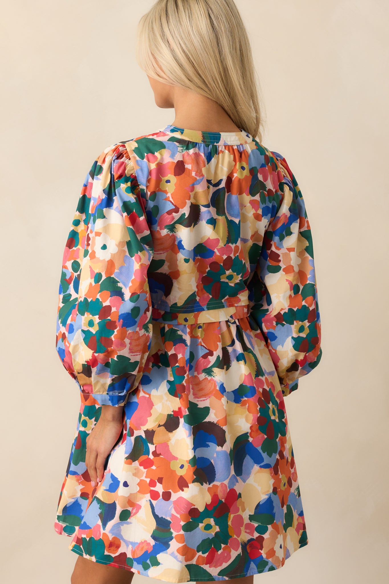 Rear view of the mini dress showing long balloon sleeves, button cuffs, and functional pockets.