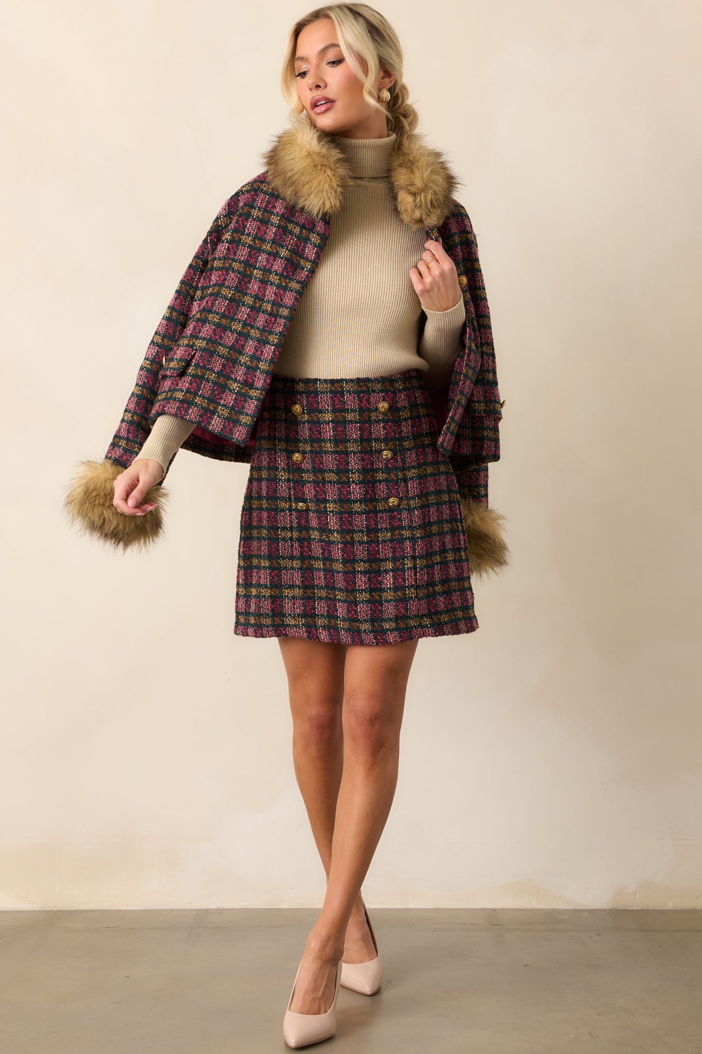 Tailored plaid mini skirt featuring six gold buttons and a structured tweed fabric.