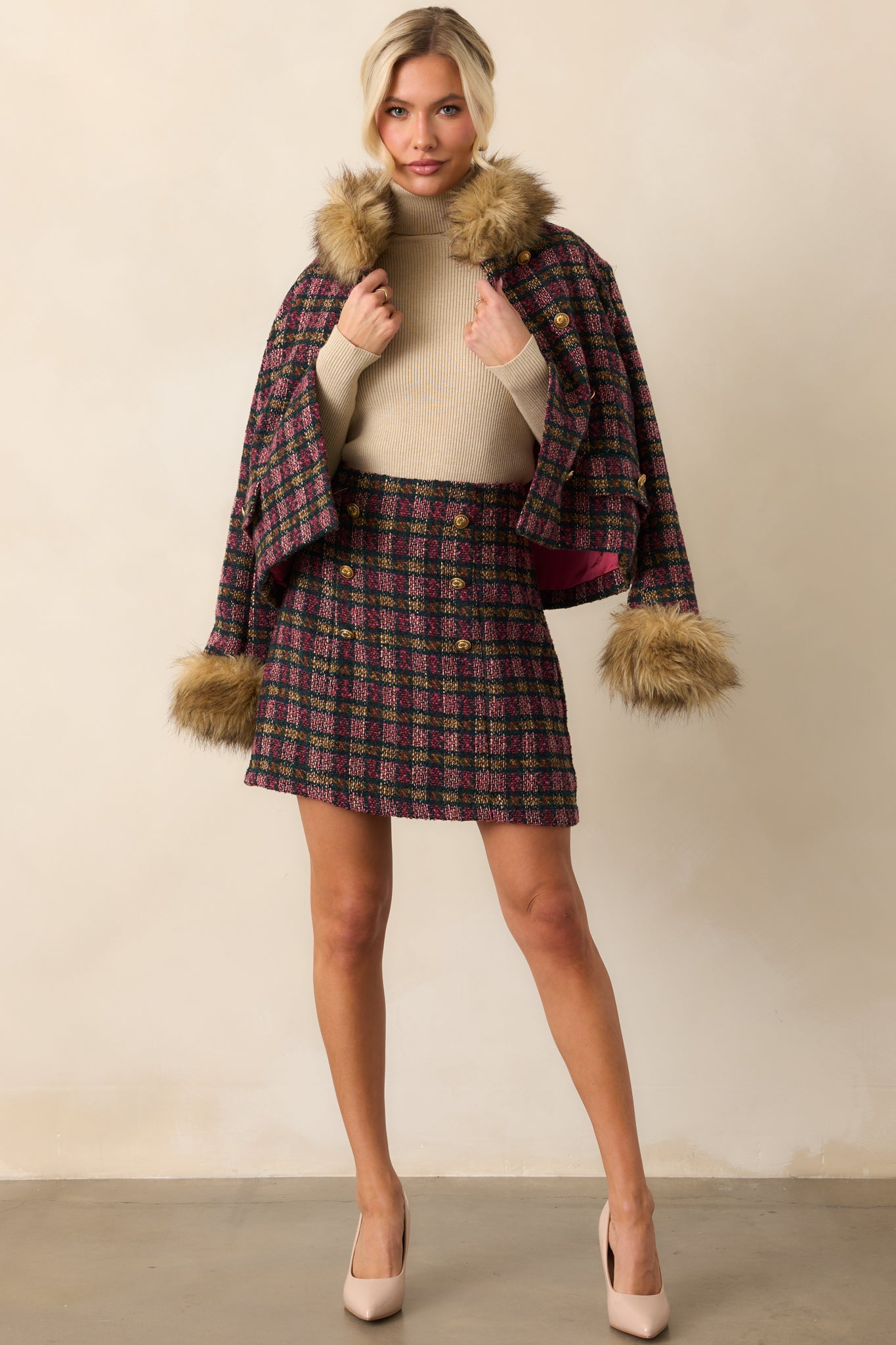 Pink plaid tweed skirt showing its classic mini length and polished double-breasted front.