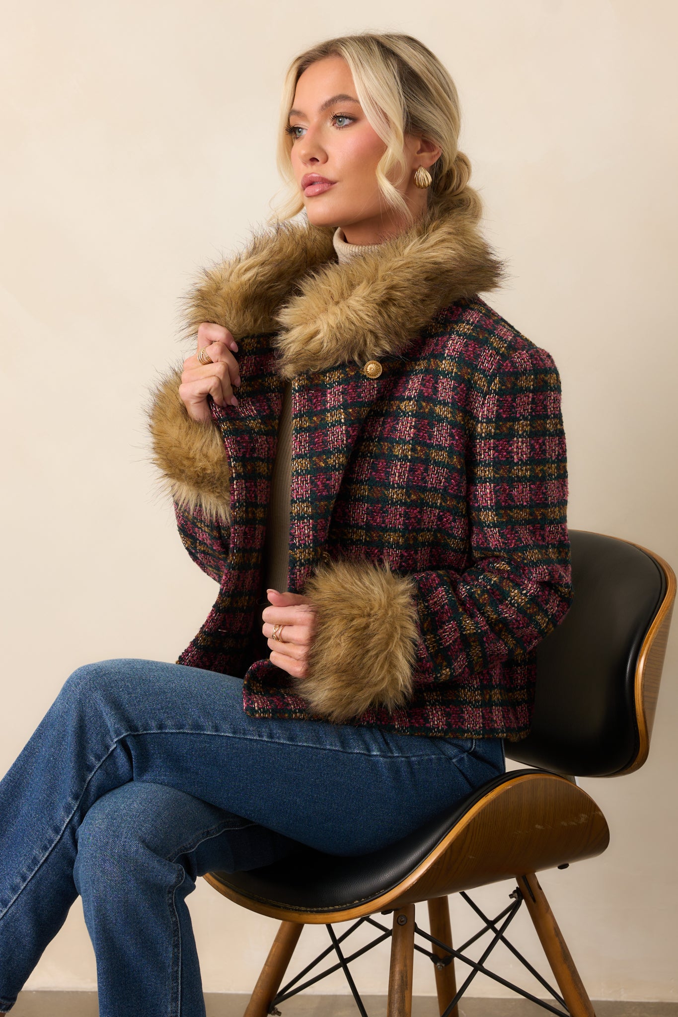  Focus on the faux fur collar and textured plaid pattern of the jacket.