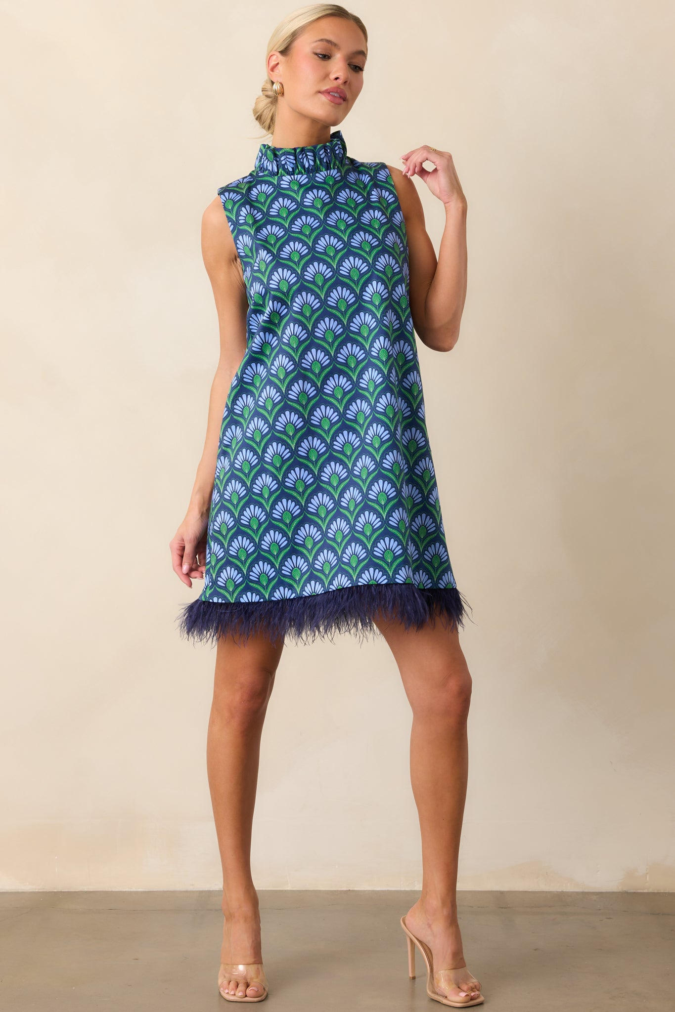 Blue geometric print dress with sleeveless cut, concealed back zipper, and feather-accented hem.