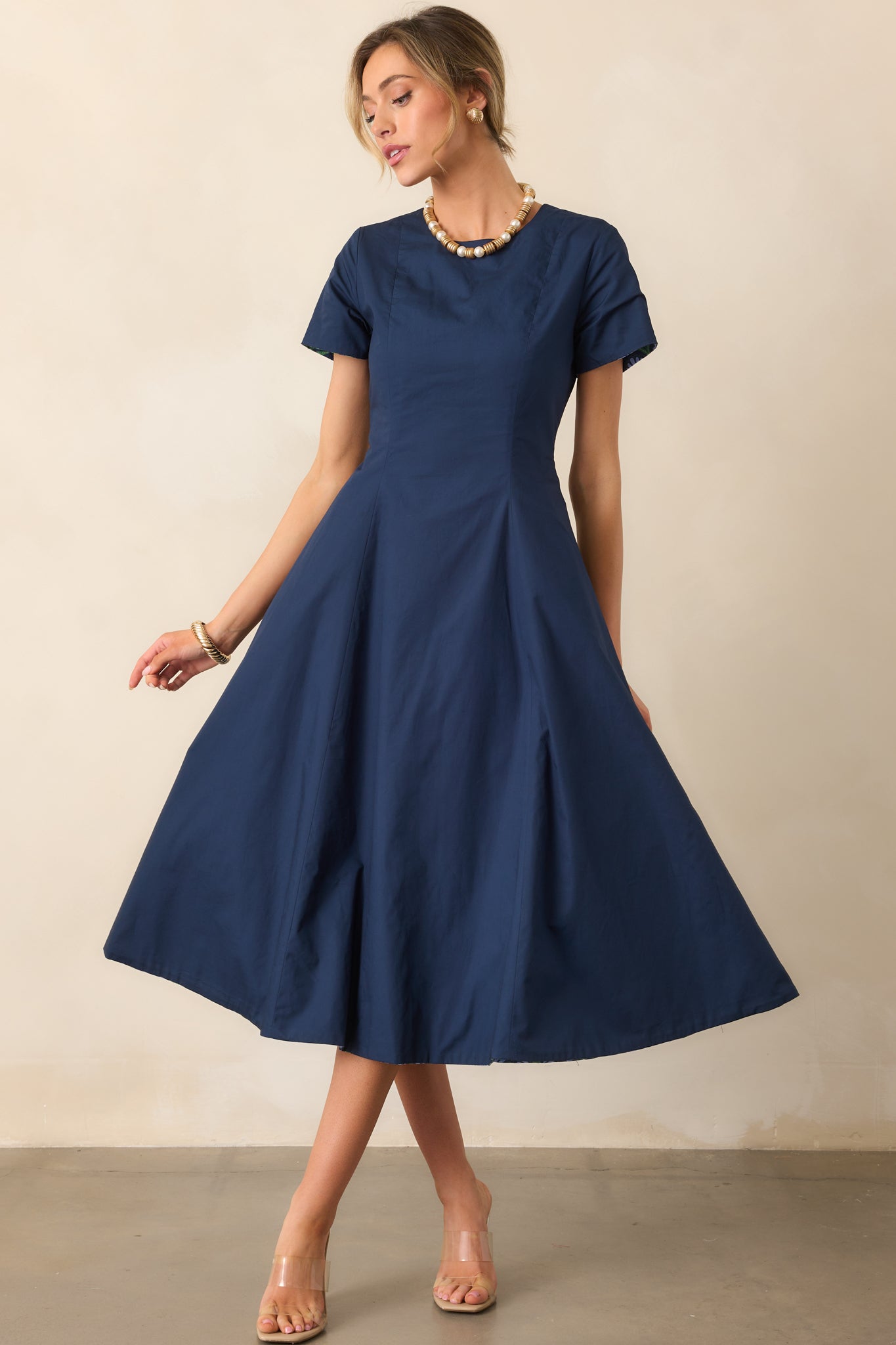 Dress highlighting short sleeves and the smooth solid midnight blue fabric.