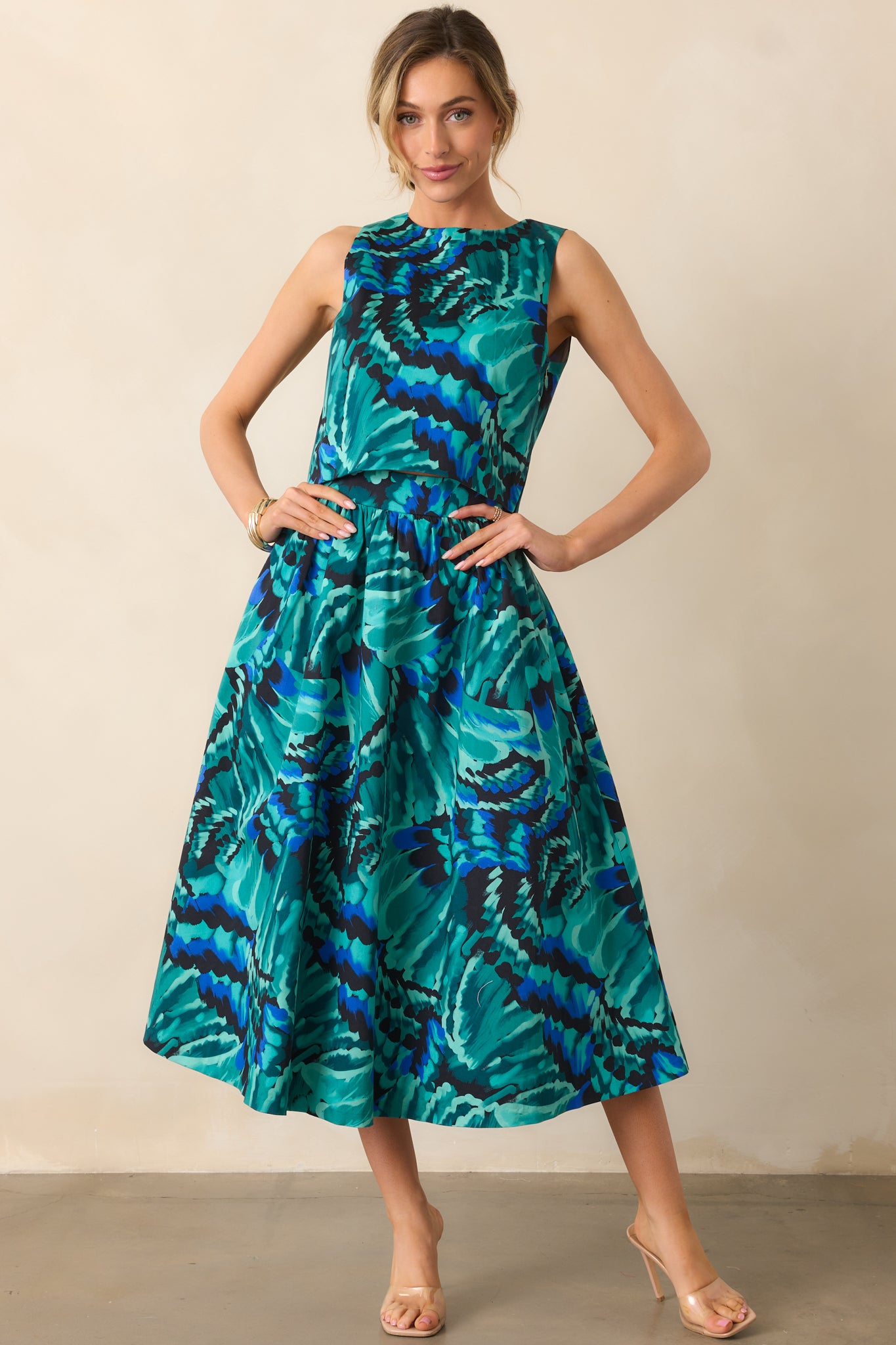 Blue abstract print midi skirt styled to show its high-rise waist and fluid A-line shape.