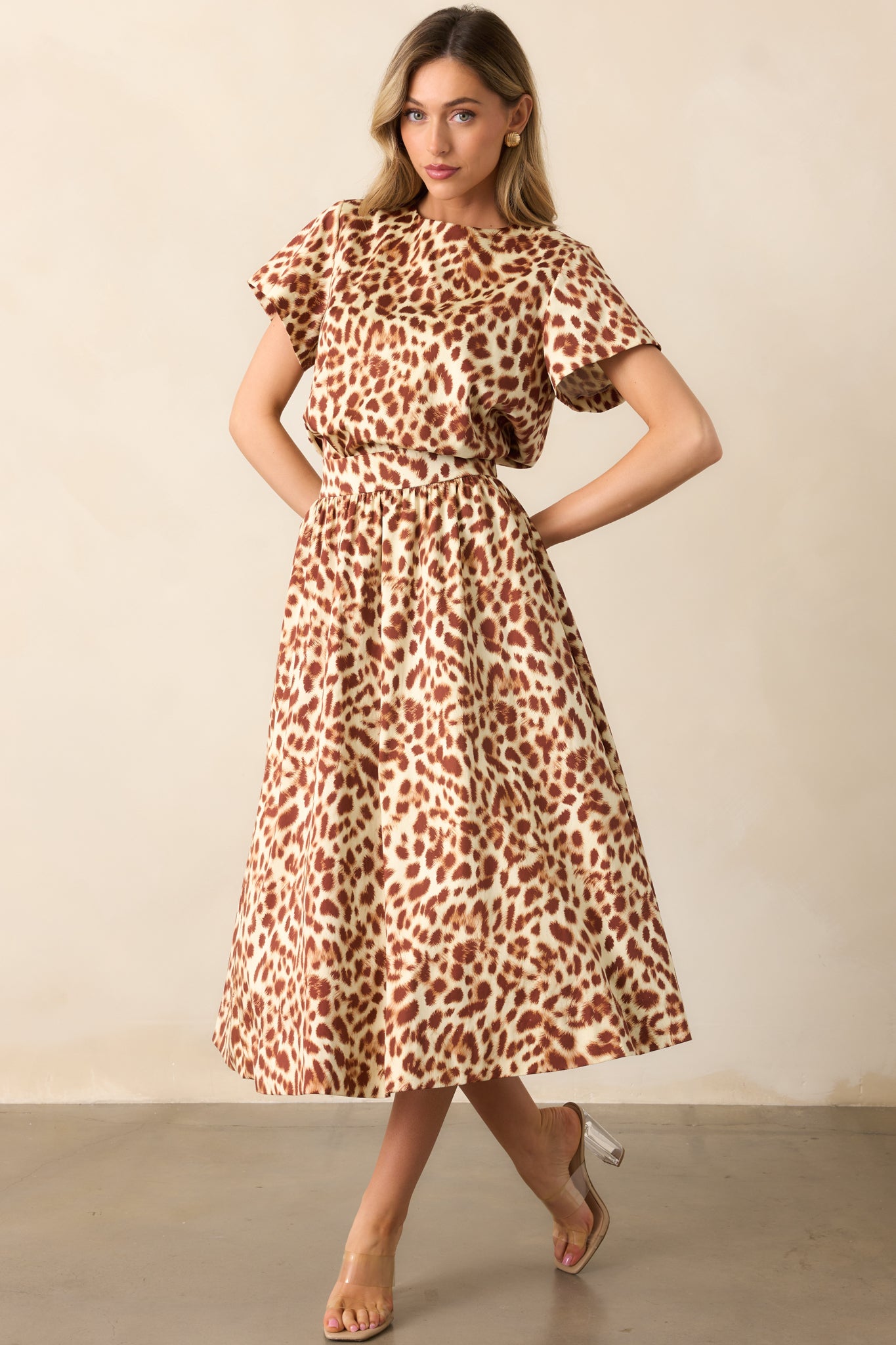 Midi skirt with an ivory and brown abstract leopard print, high-rise waist, and flowing silhouette.