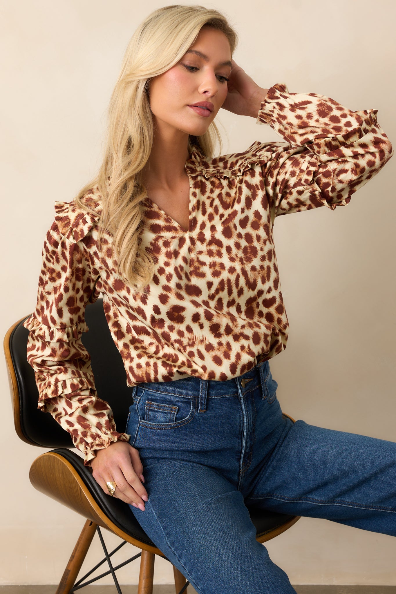 Ivory and brown abstract leopard print top with a split v-neckline and long sleeves.