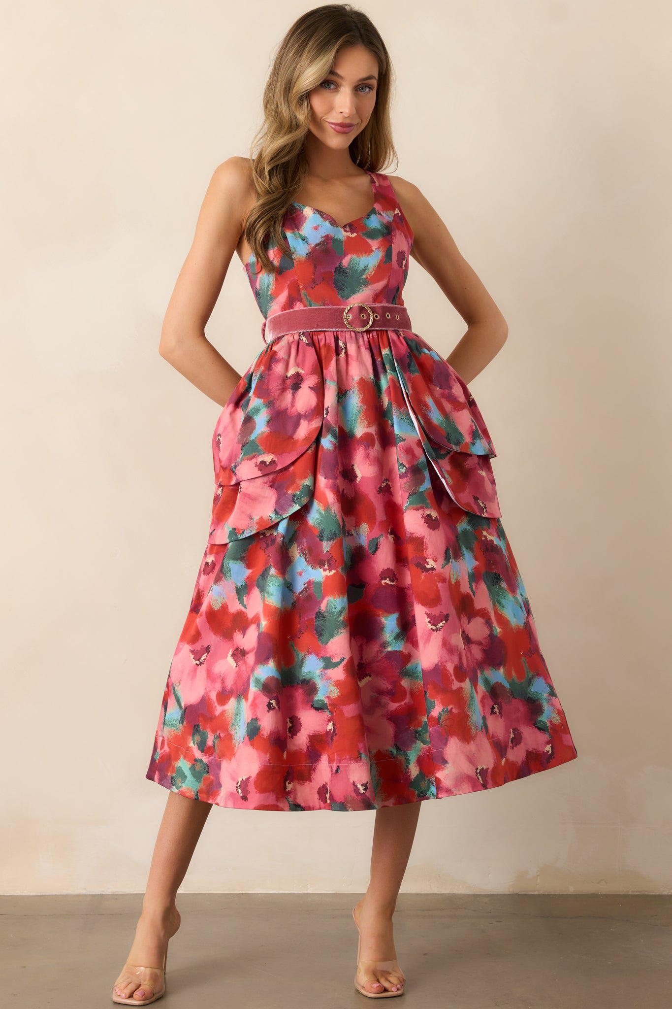 Sleeveless midi dress with a scoop neckline and tiered peplum overskirts emphasizing the waist.