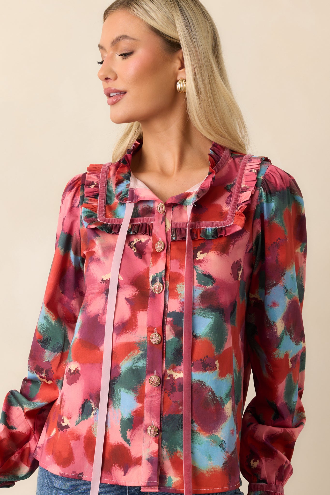 Cropped view focusing on the top’s button-front closure and abstract floral pattern with puffed long sleeves.