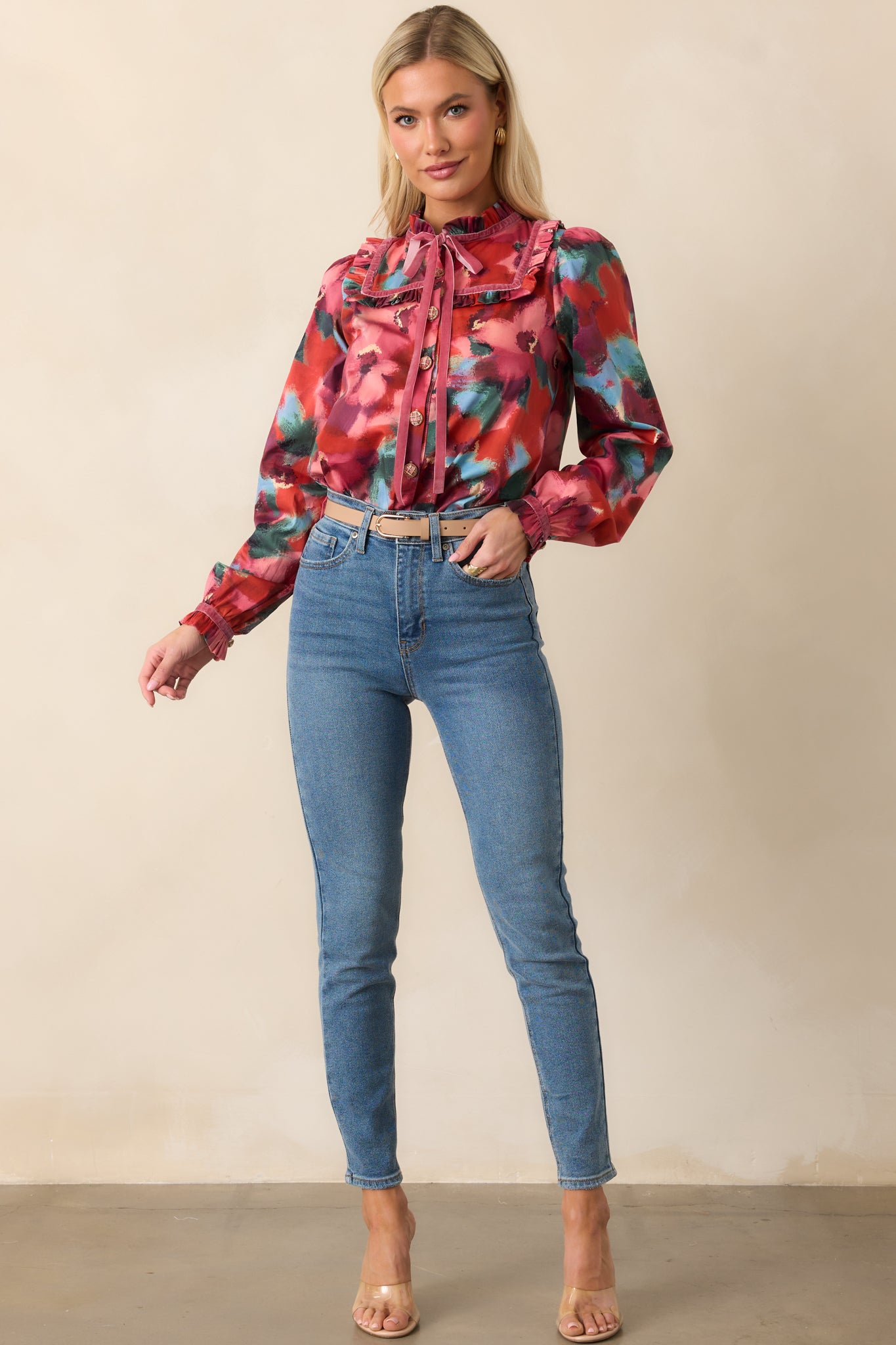 Front view of a pink top with multicolor abstract floral print, sailor-style ruffle collar, V-neck with long ribbon ties, and long puff sleeves with ruffle cuffs.