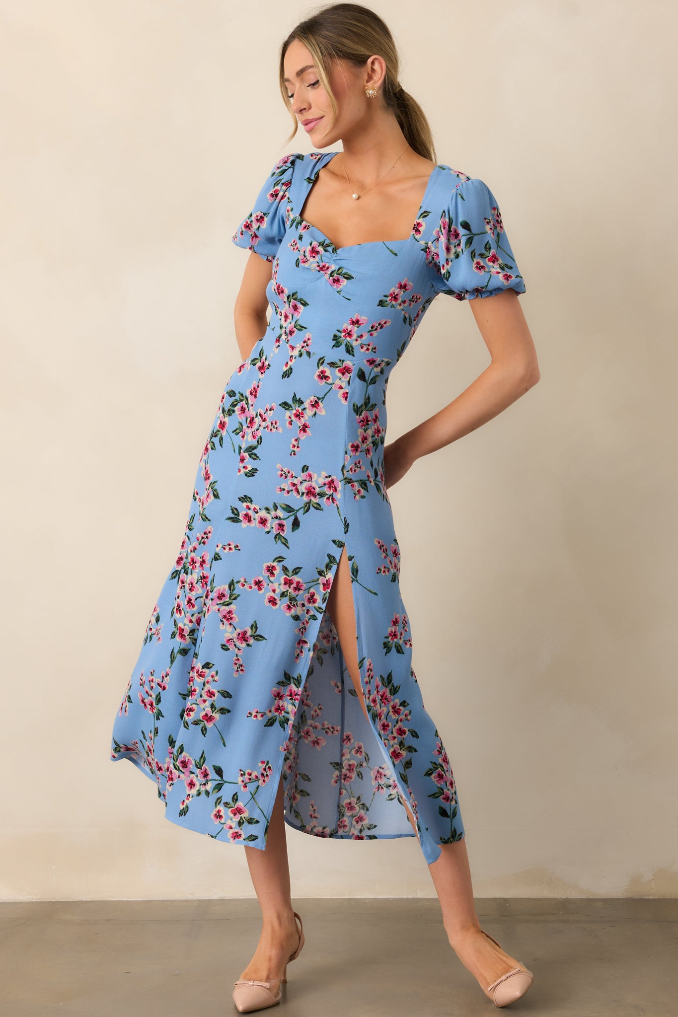 This dress stuns with its airy puff sleeves, flattering sweetheart neckline, and a subtle leg slit for added movement.