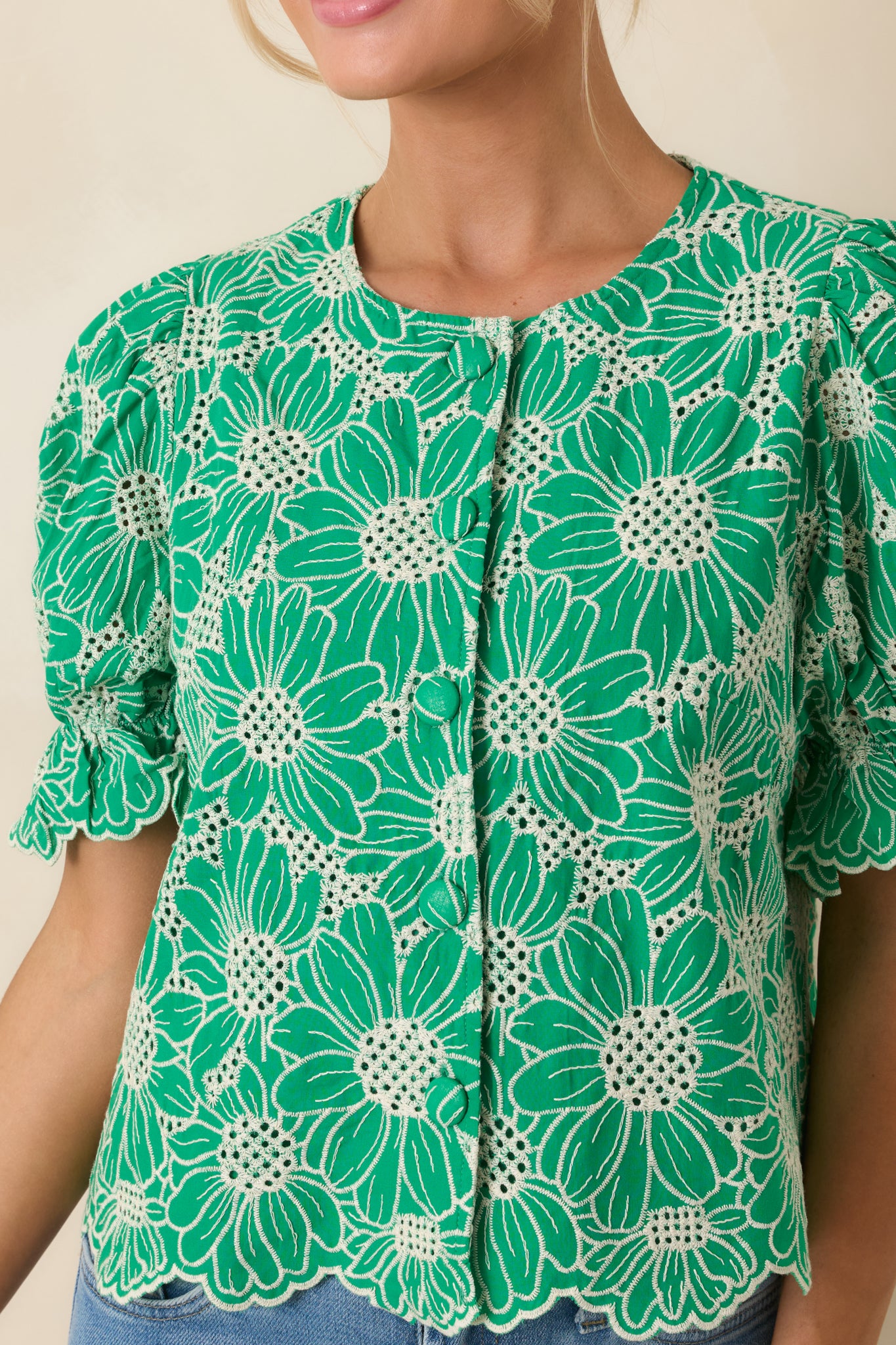 Puff sleeves and button-front closure highlighted with textured eyelet fabric.