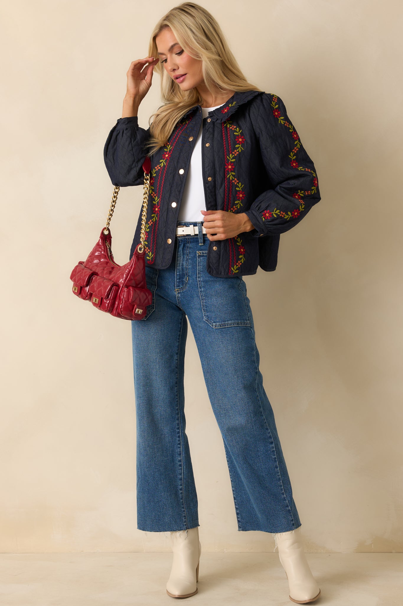 Quilted denim jacket highlighting a ruffled collar, long sleeves, and snap-button closure.