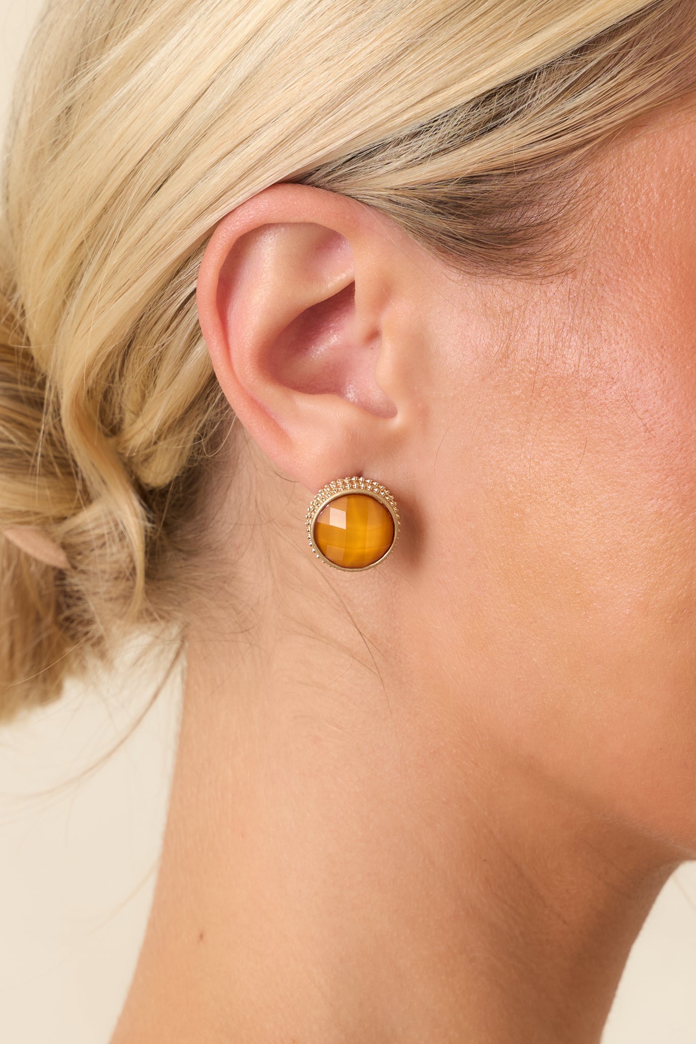 Elegant stud earrings showcasing radiant orange stones with polished gold framing.