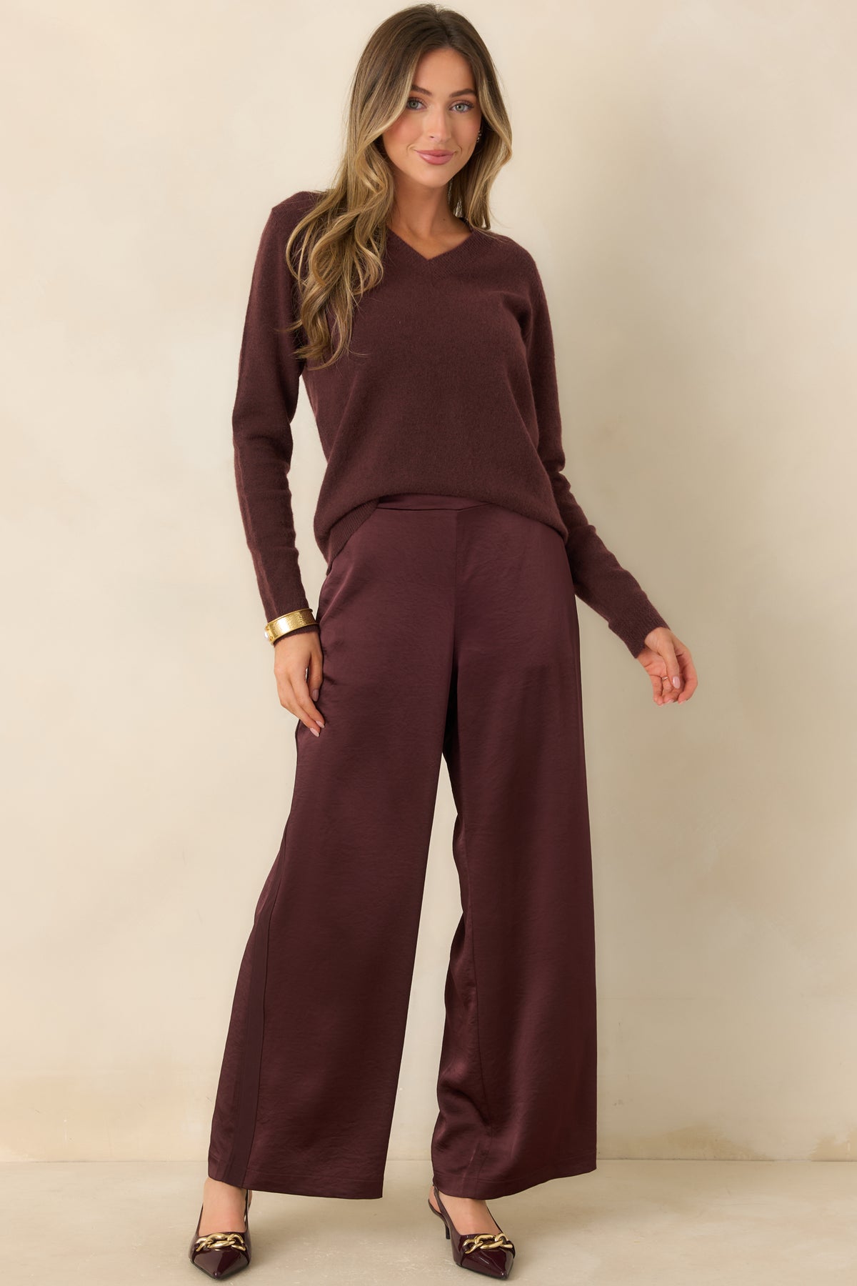 Raisin-colored knit top with muted plum-brown undertones, a classic V-neckline, and a softly relaxed fit.