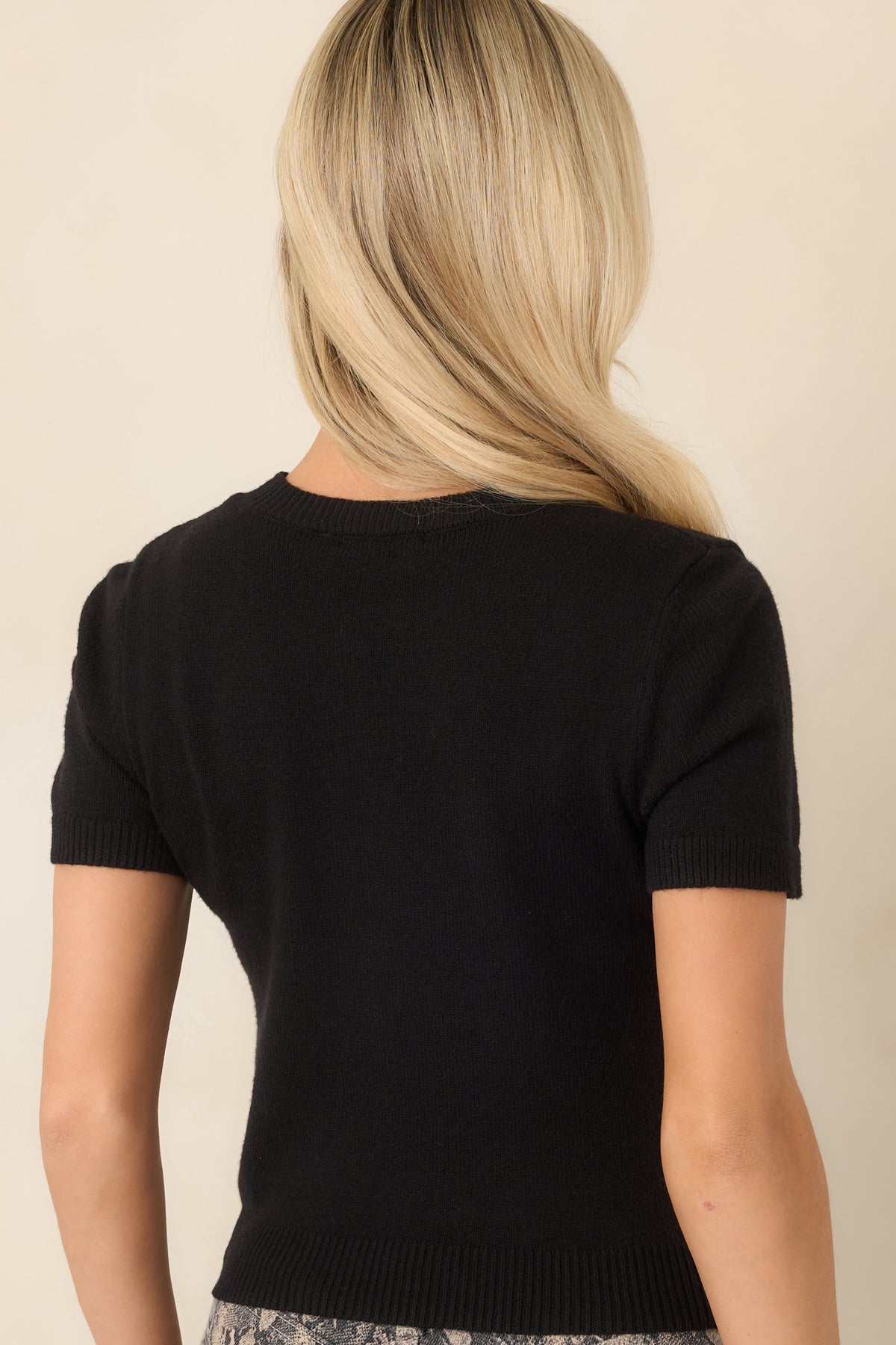 Rear view of the rayon-blend knit top showing its short sleeves and ribbed neckline and hem.