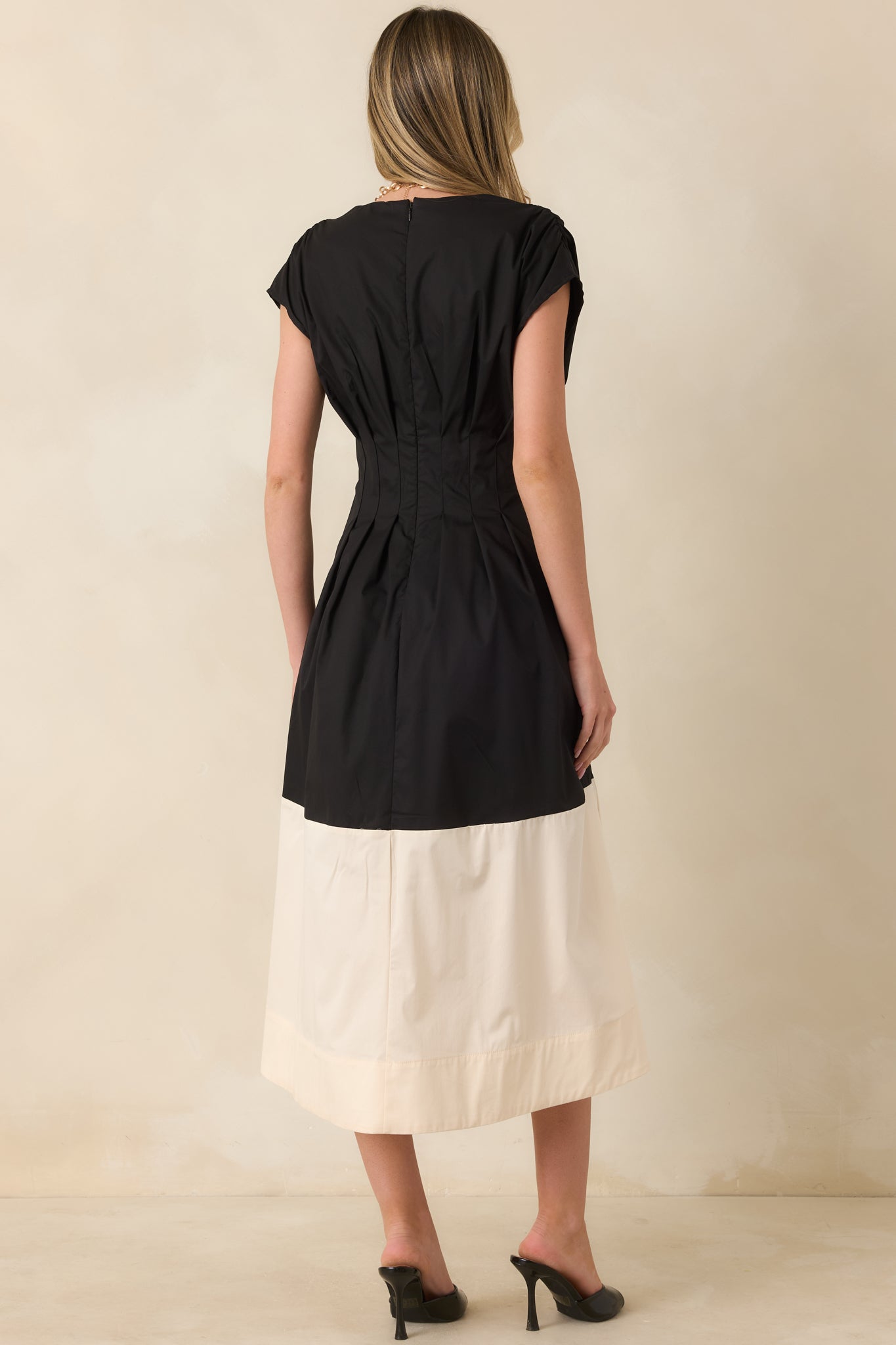 Rear view of the black and ivory midi dress featuring a concealed zipper closure and a fully lined cotton blend construction.