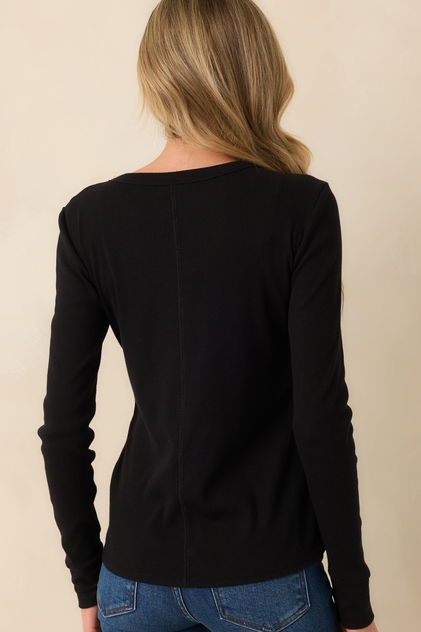 Rear view of the black top displaying the center seam detail and smooth drape of the ribbed fabric across the back.