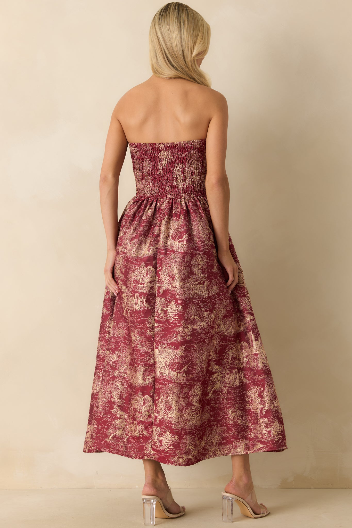 Rear view of the burgundy strapless midi dress showing the hidden back zipper, full lining, and voluminous A-line skirt.

