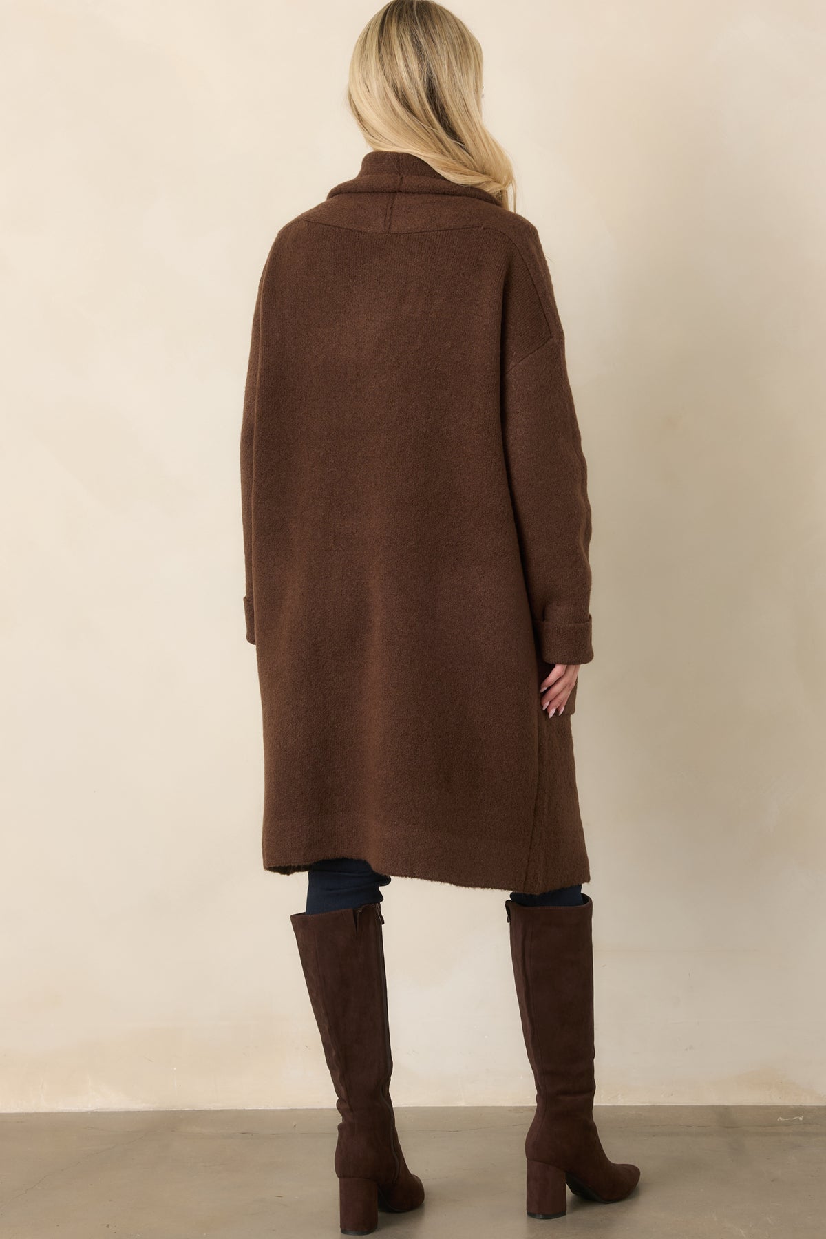 Rear of the chocolate brown cardigan showing its relaxed shape, dropped shoulders, long sleeves, and knit construction.