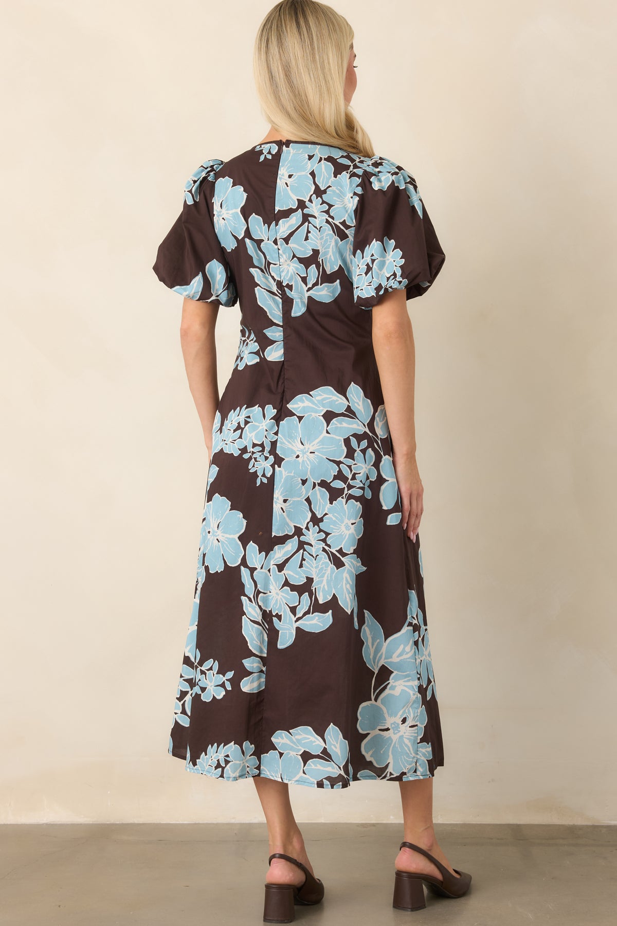 Rear of the chocolate floral midi dress showcasing the defined waist, short puff sleeves, and gently flared skirt.