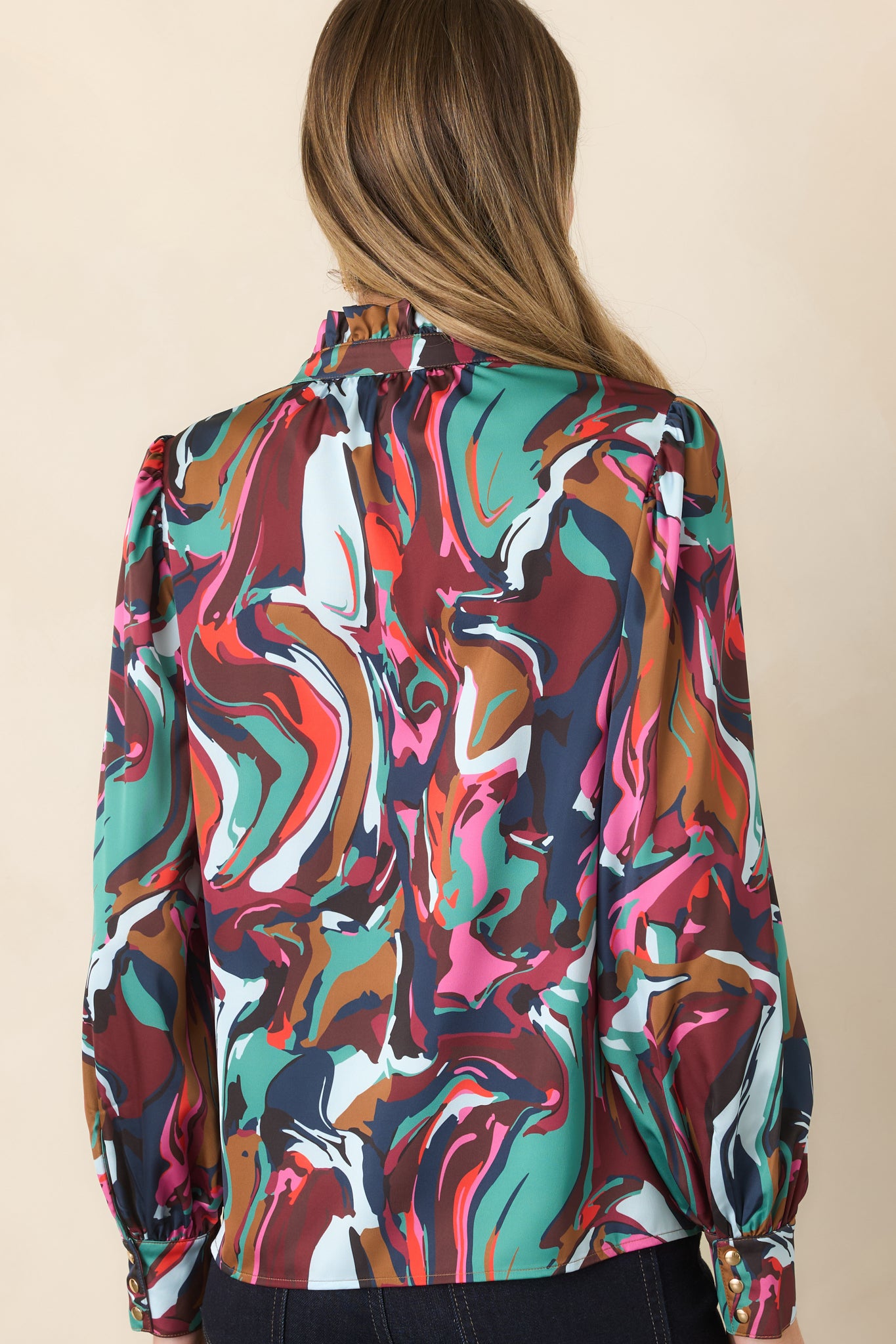 Rear view of the Color Current print blouse showcasing its flowing silhouette, softly gathered shoulders, and long blouson sleeves with buttoned cuffs.