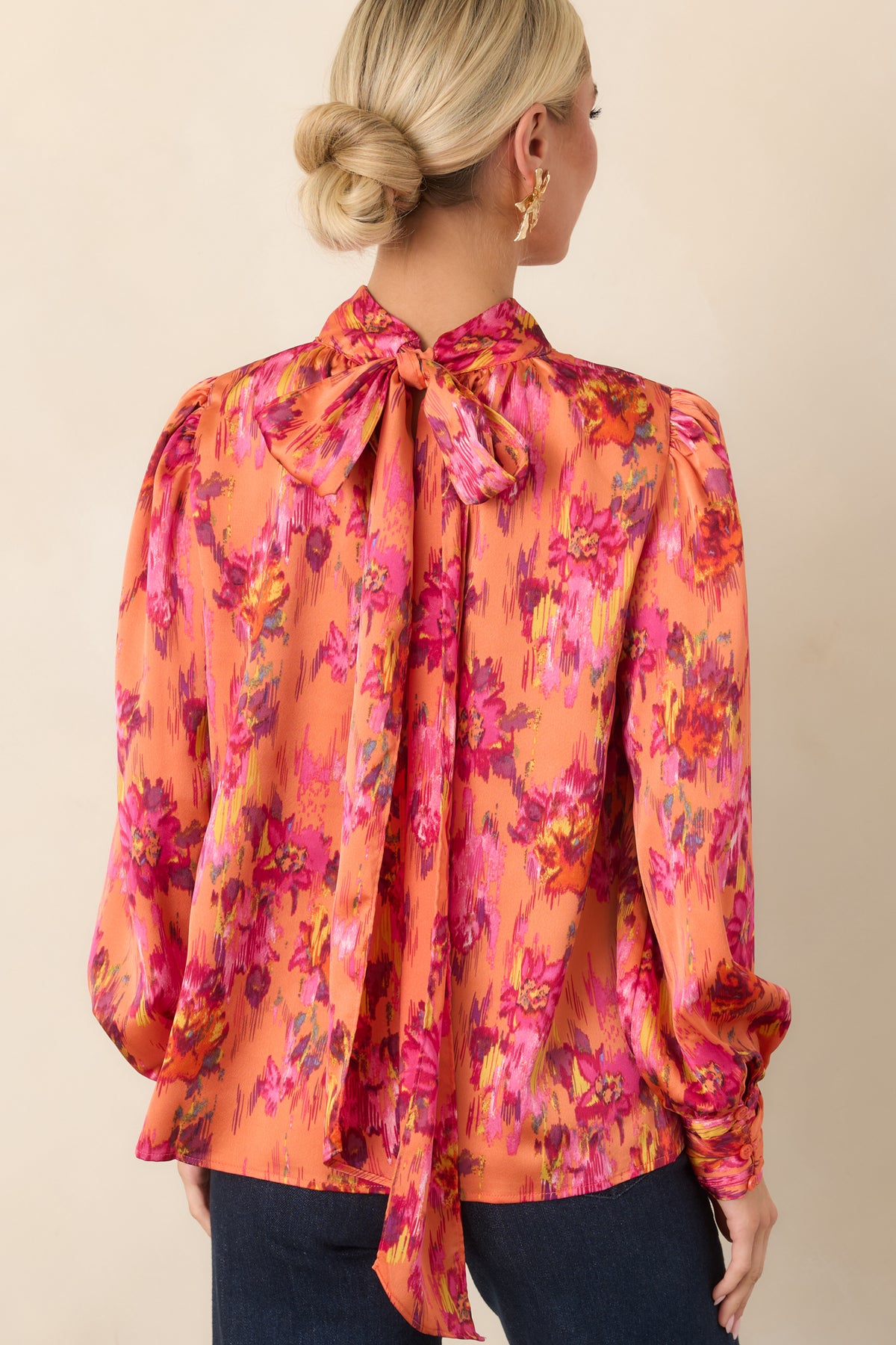 Rear view of the colorful satin top showcasing its smooth drape, lightly gathered shoulders, voluminous balloon sleeves, and buttoned cuffs.
