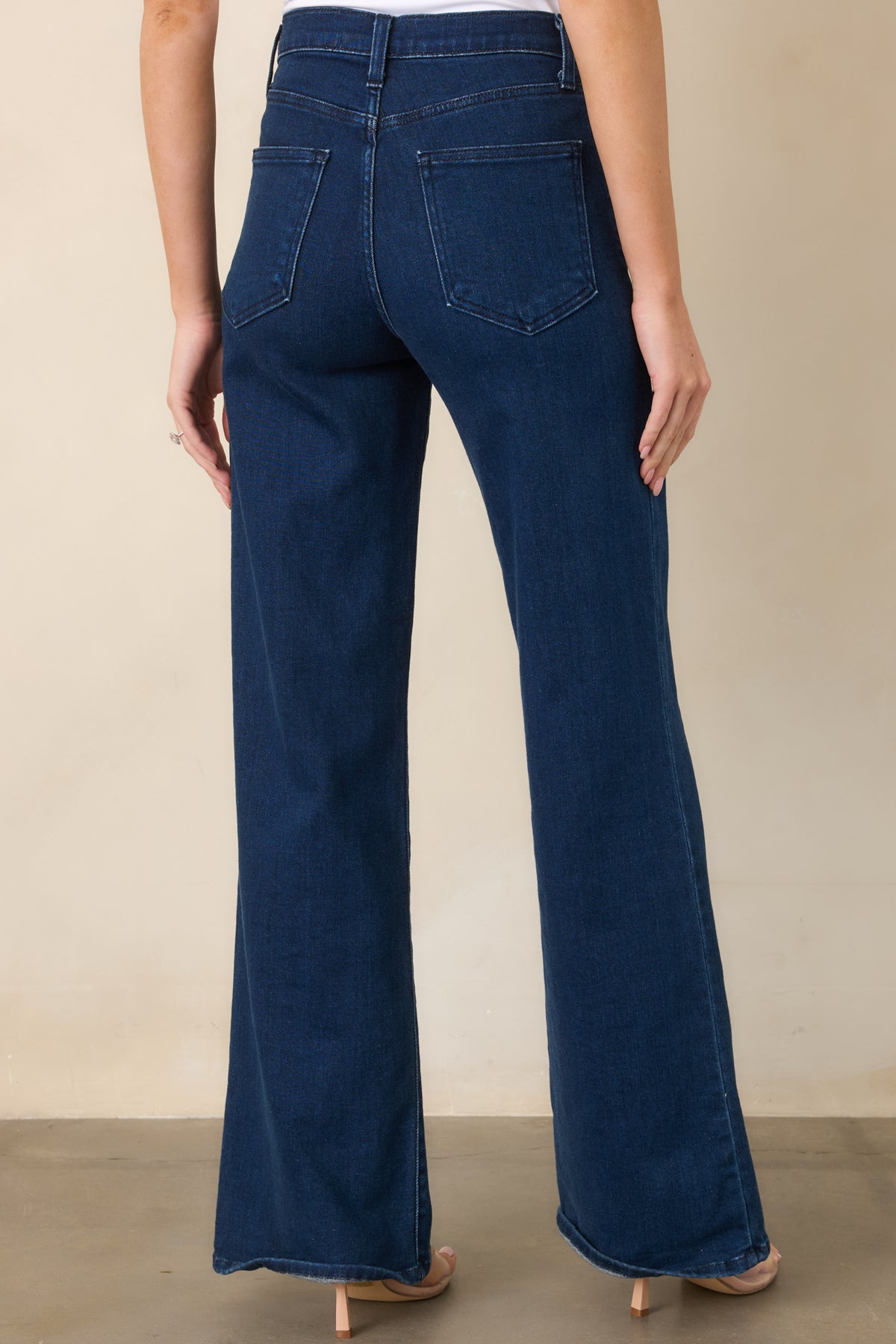 Rear of the dark wash jeans featuring functional back pockets and a wide-leg silhouette.
