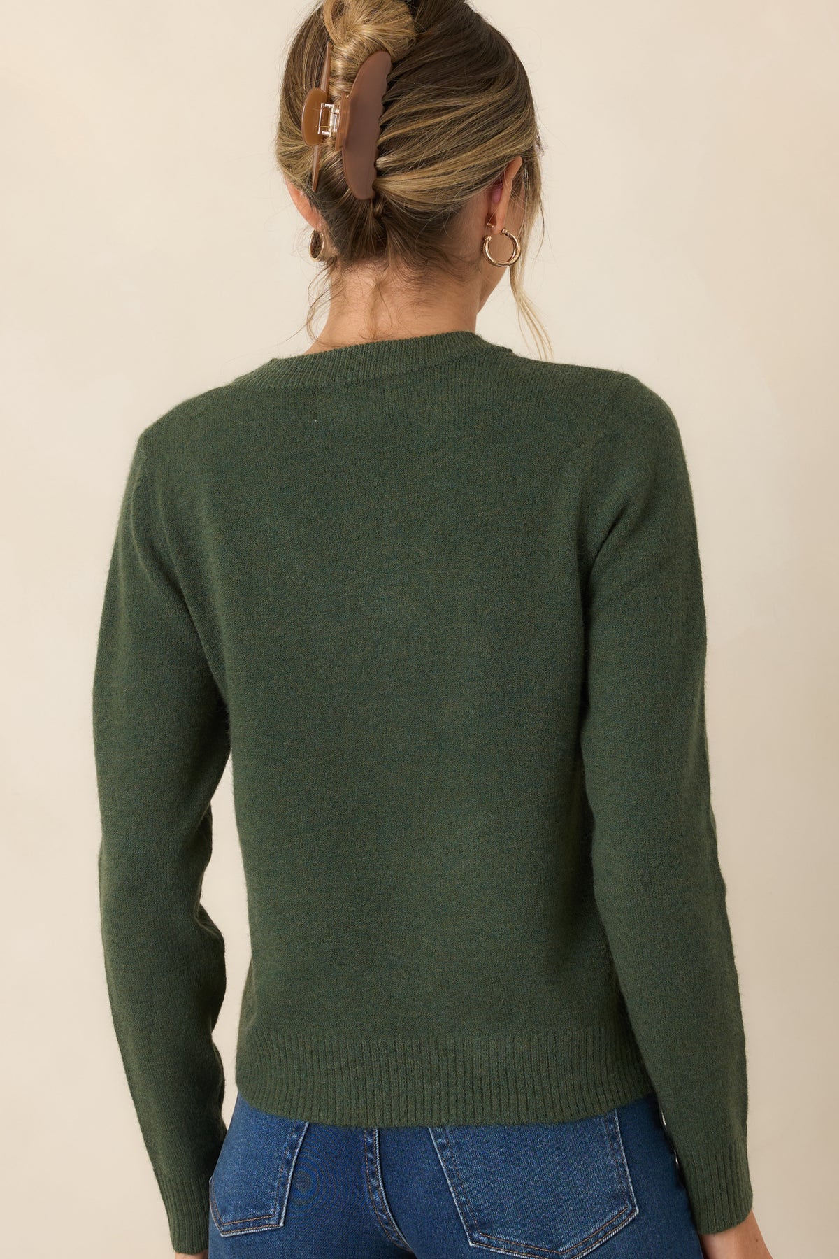 Rear of the earthy green knit top showing its relaxed silhouette and ribbed hem.