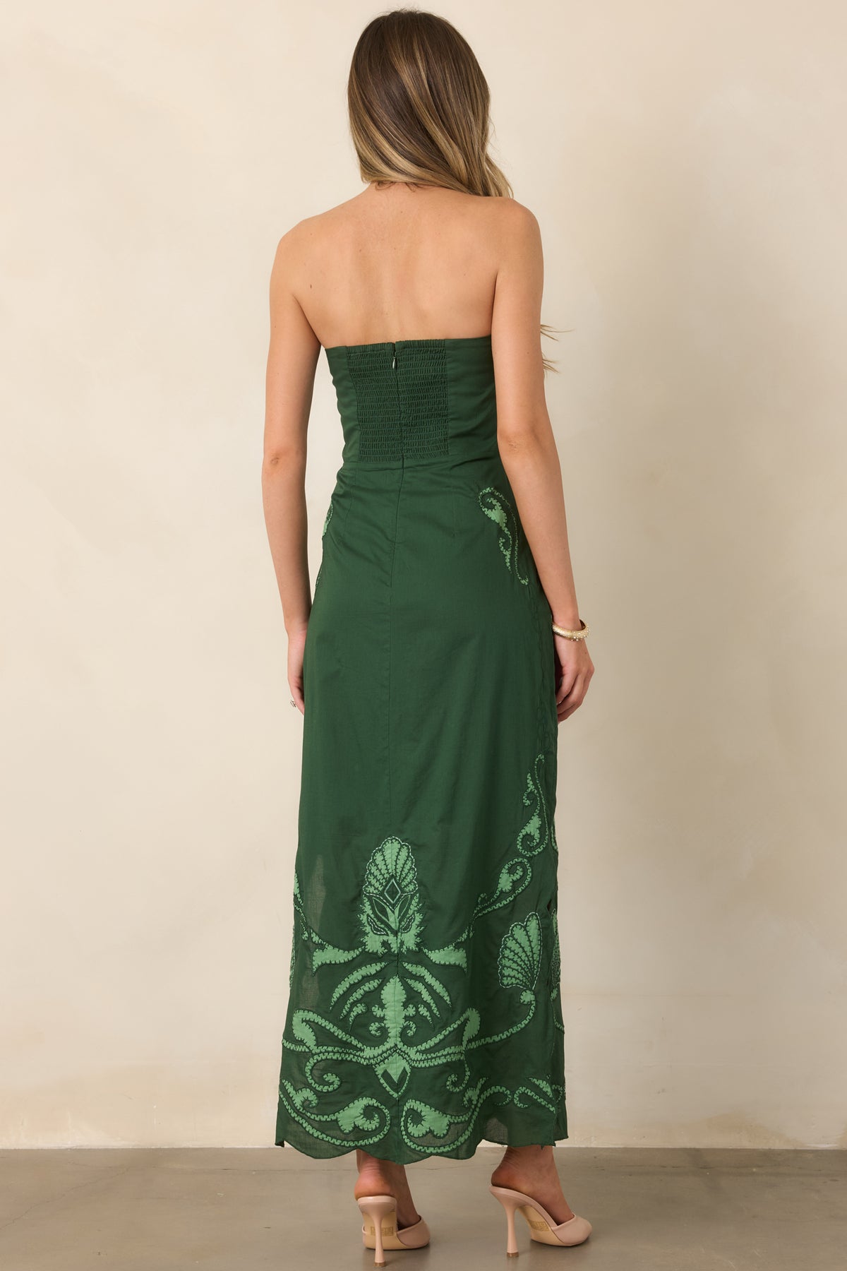 Rear of the fitted midi dress showing the smocked back panel and concealed zipper.