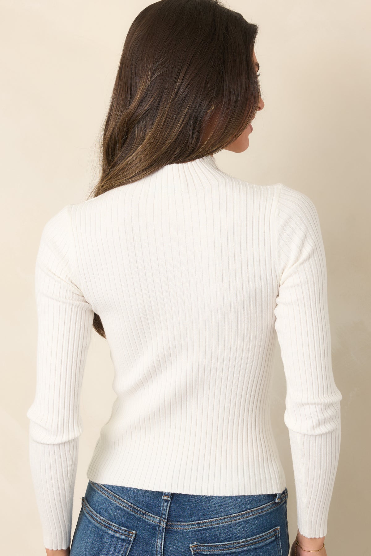 Rear view shows the fitted ribbed knit construction continuing through the sleek silhouette and long sleeves.