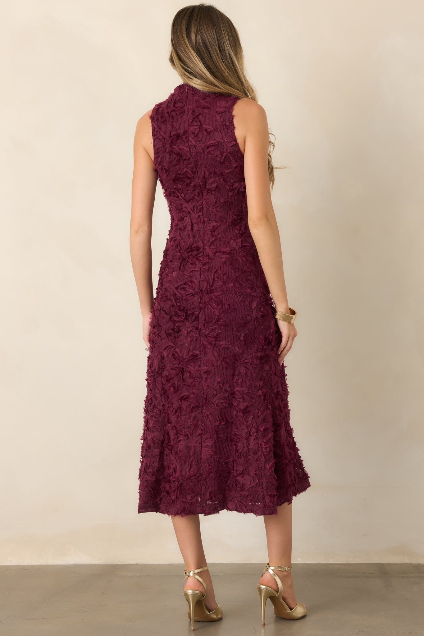 Rear view of the floral appliqué knit midi dress showcasing its sleeveless cut, fitted silhouette, softly flared skirt, and concealed back zipper.