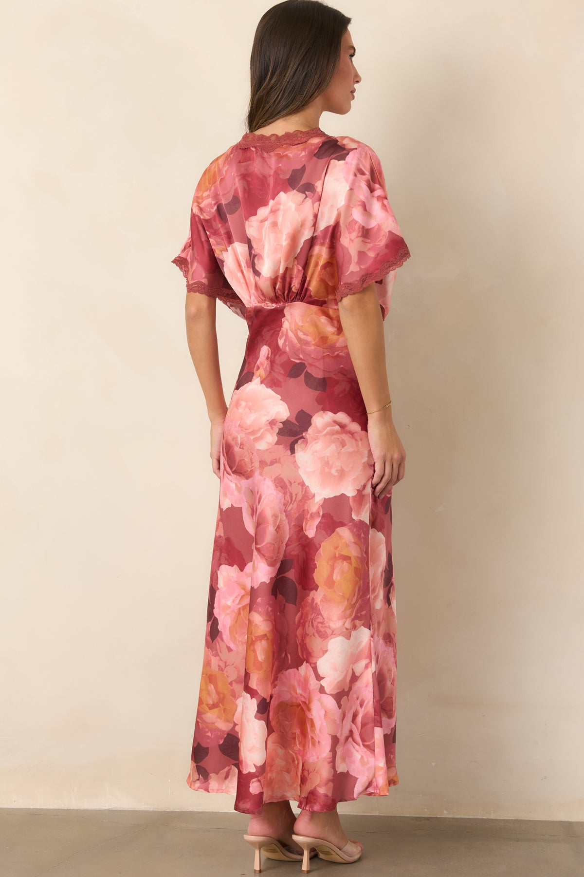 Rear of the floral satin maxi dress showcasing the defined waist, flutter sleeves, and flowing floor-length skirt.