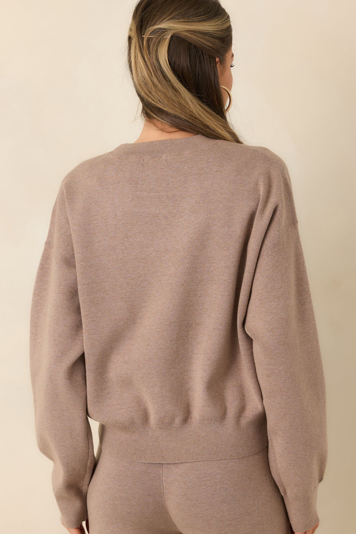 Rear of the heathered taupe pullover featuring dropped shoulders, long sleeves, and a ribbed hem.