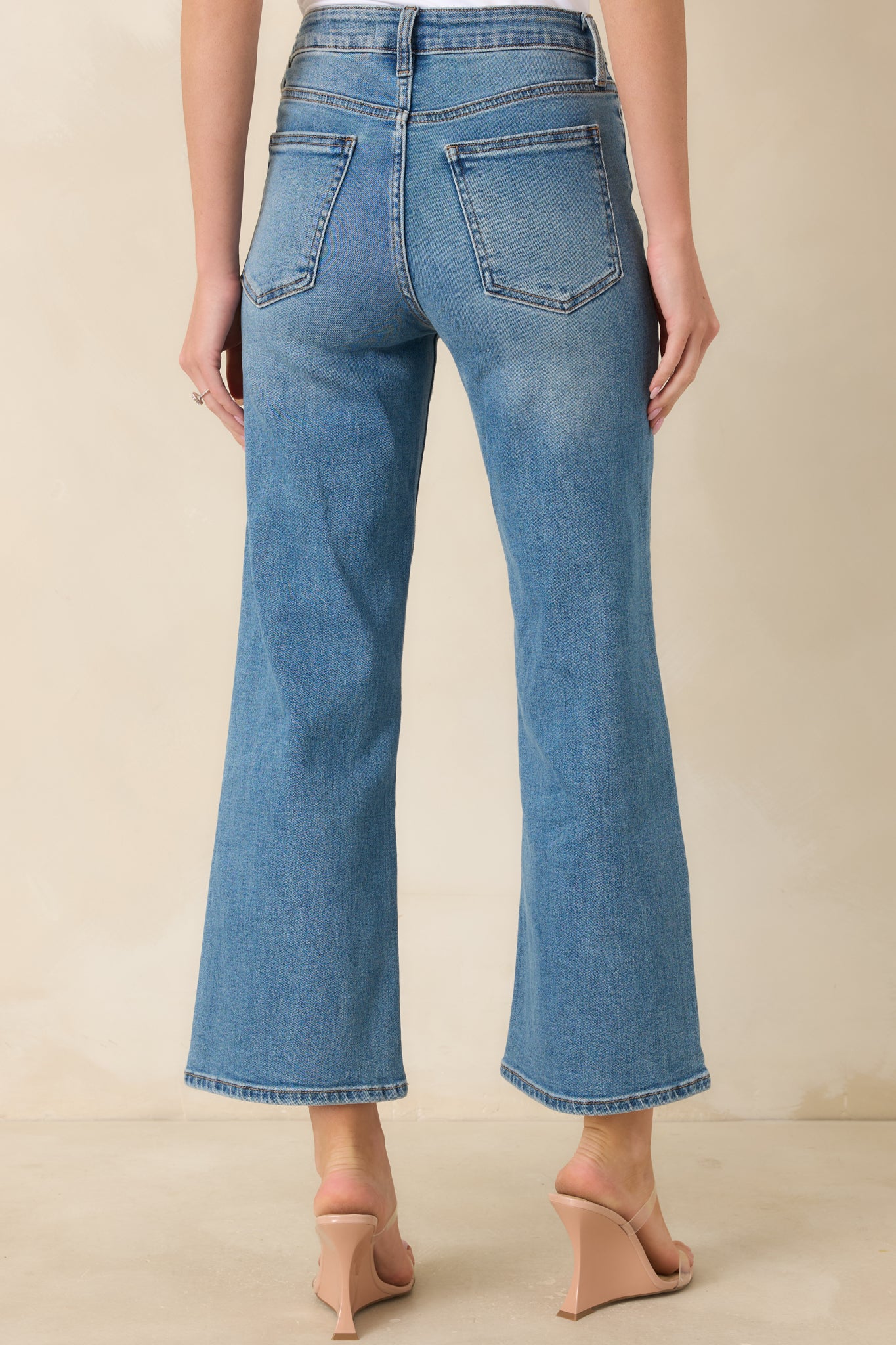 Rear view of the high-waisted cropped jeans showcasing the back pockets, belt loops, and classic denim silhouette.