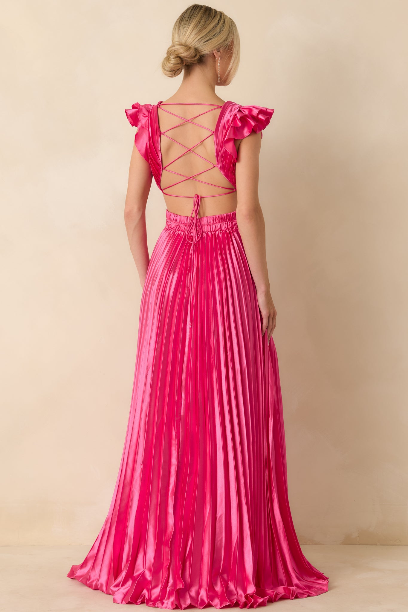 Rear perspective highlighting adjustable lace-up fit, ruffled cap sleeves, and pleated skirt movement.