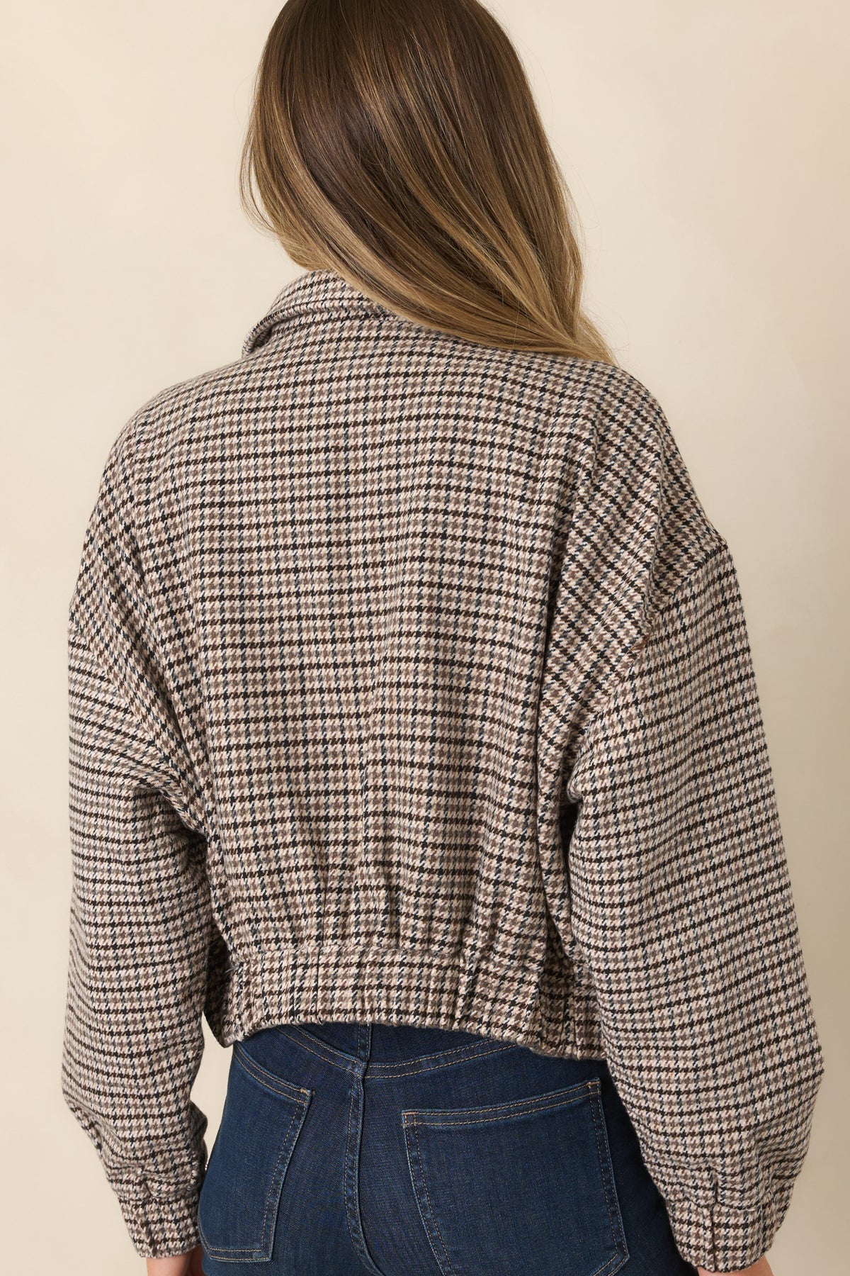 The rear of the jacket features the classic houndstooth pattern, dropped shoulders, and cropped hem.