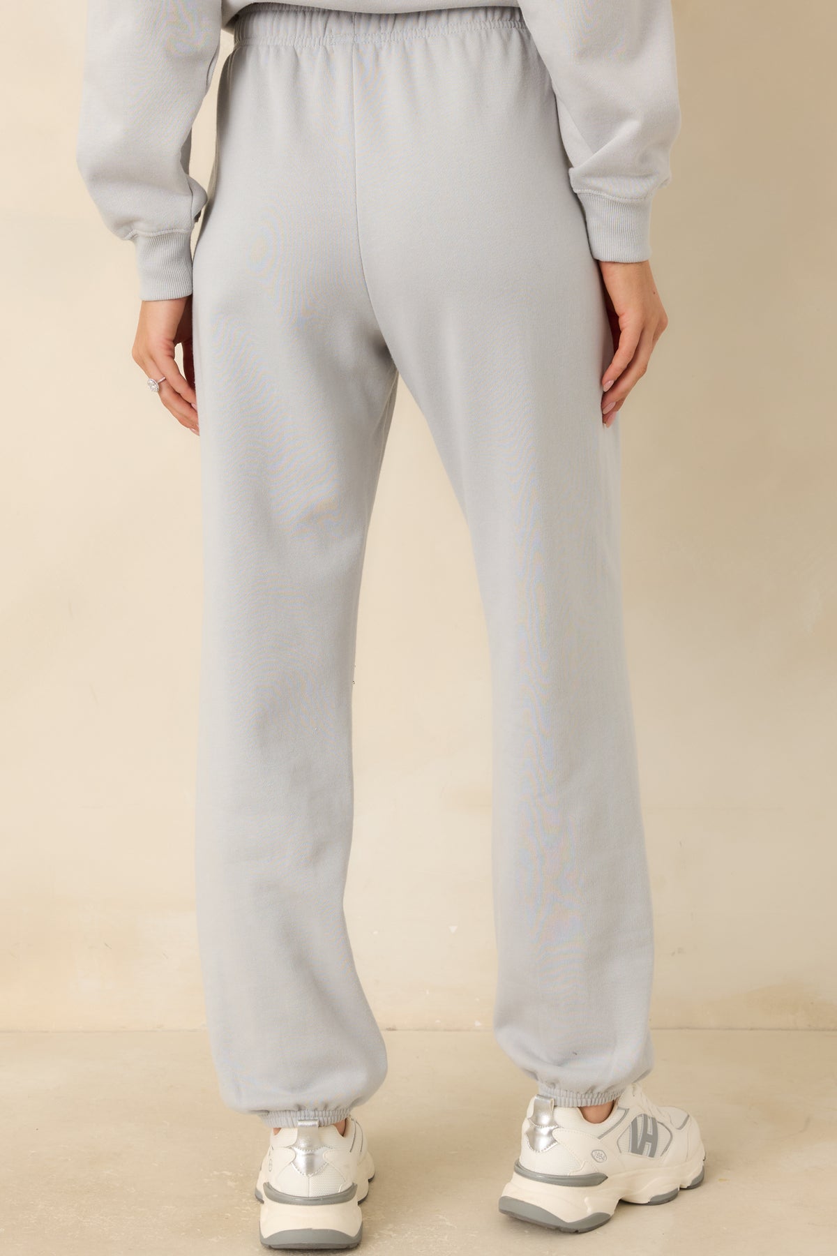 Rear of the icy grey fleece joggers featuring a relaxed fit, smooth waistband, and elasticized ankle cuffs.