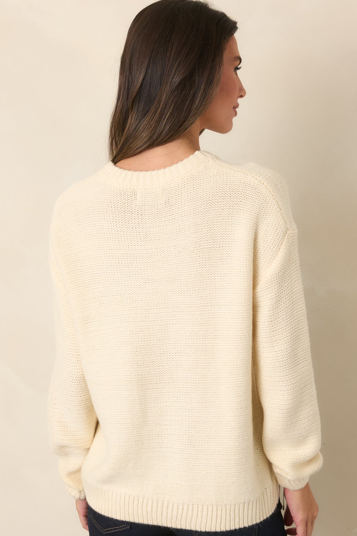 Rear view of the ivory pullover sweater showing its relaxed fit, crew neckline, and long sleeves.