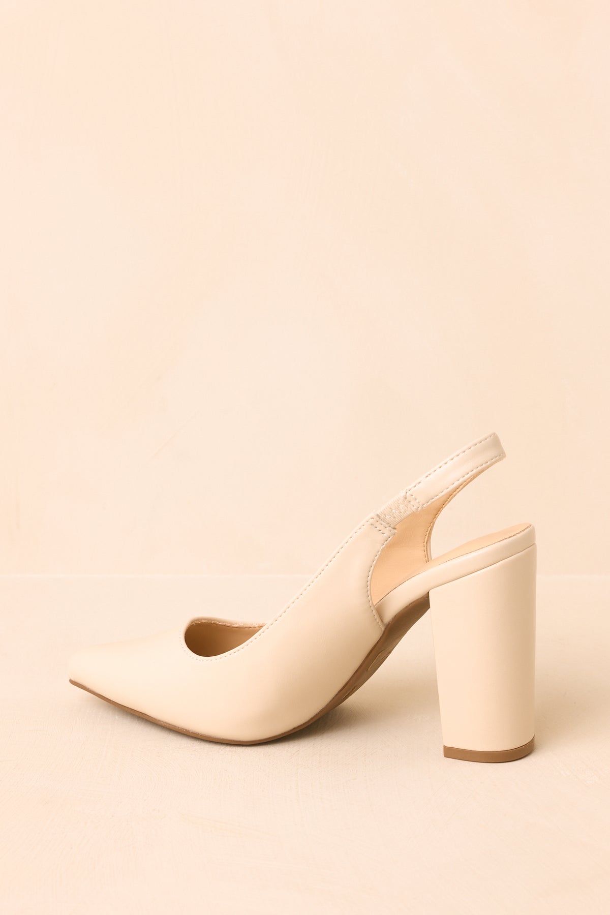 Rear view of the ivory slingback heels showing the elasticized back straps and tall block heels.