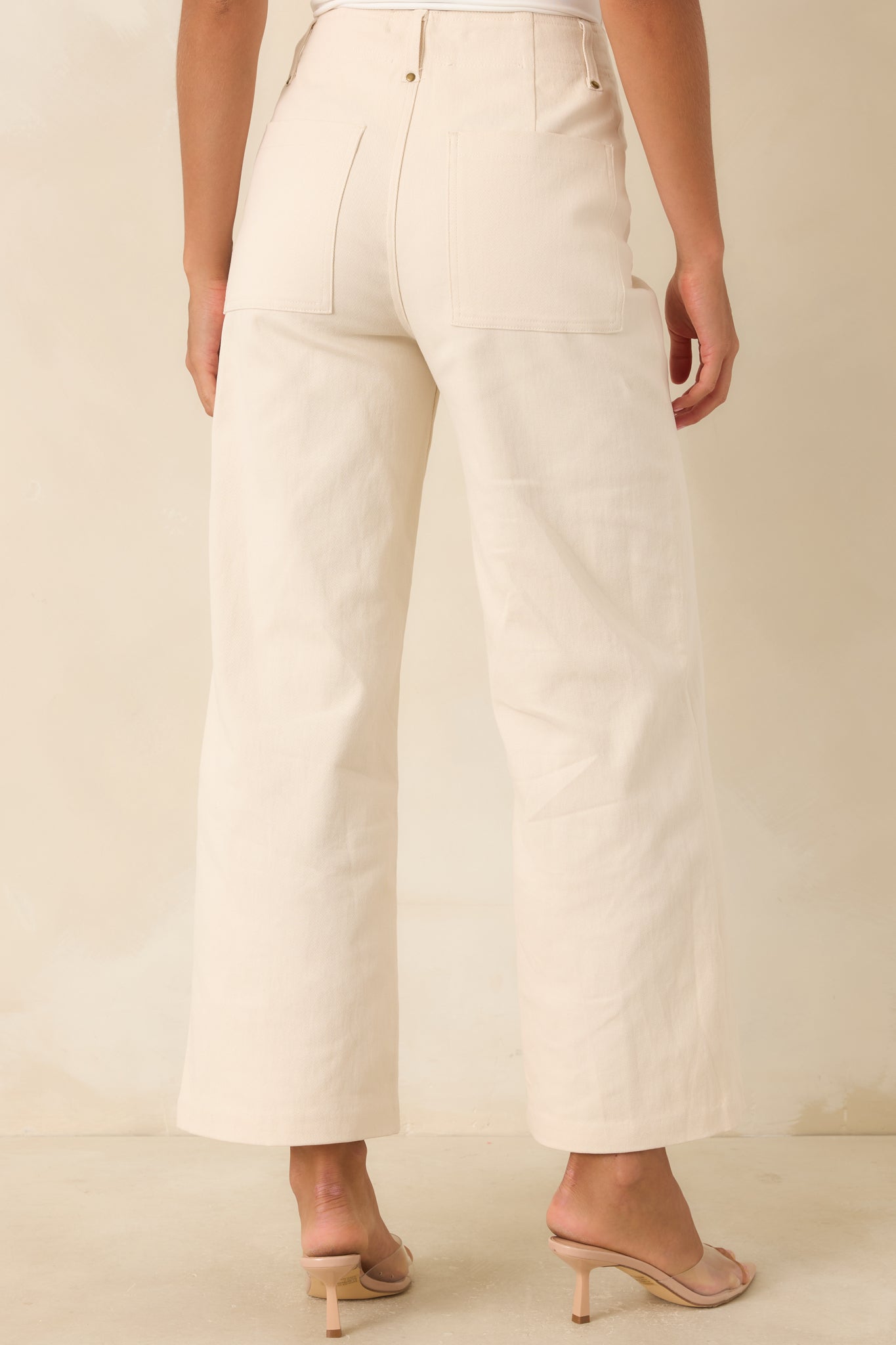 Rear view of the ivory wide leg cropped pants highlighting the oversized back patch pockets and tailored silhouette.