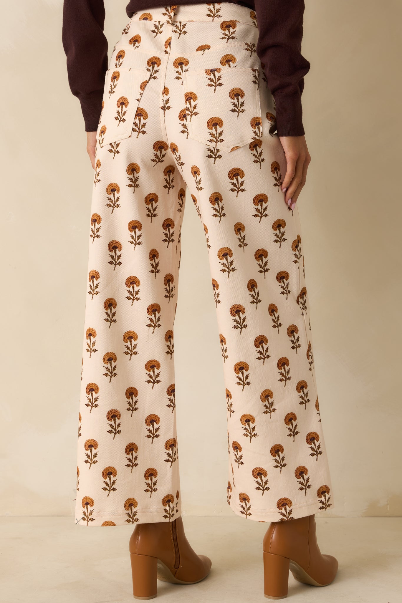 Rear view of the ivory wide leg pants showing back patch pockets and the flowing marigold floral print.