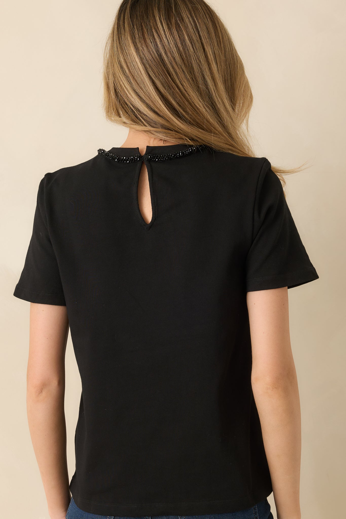 Back view showing the key-hole closure, short sleeves, and relaxed straight hem design.