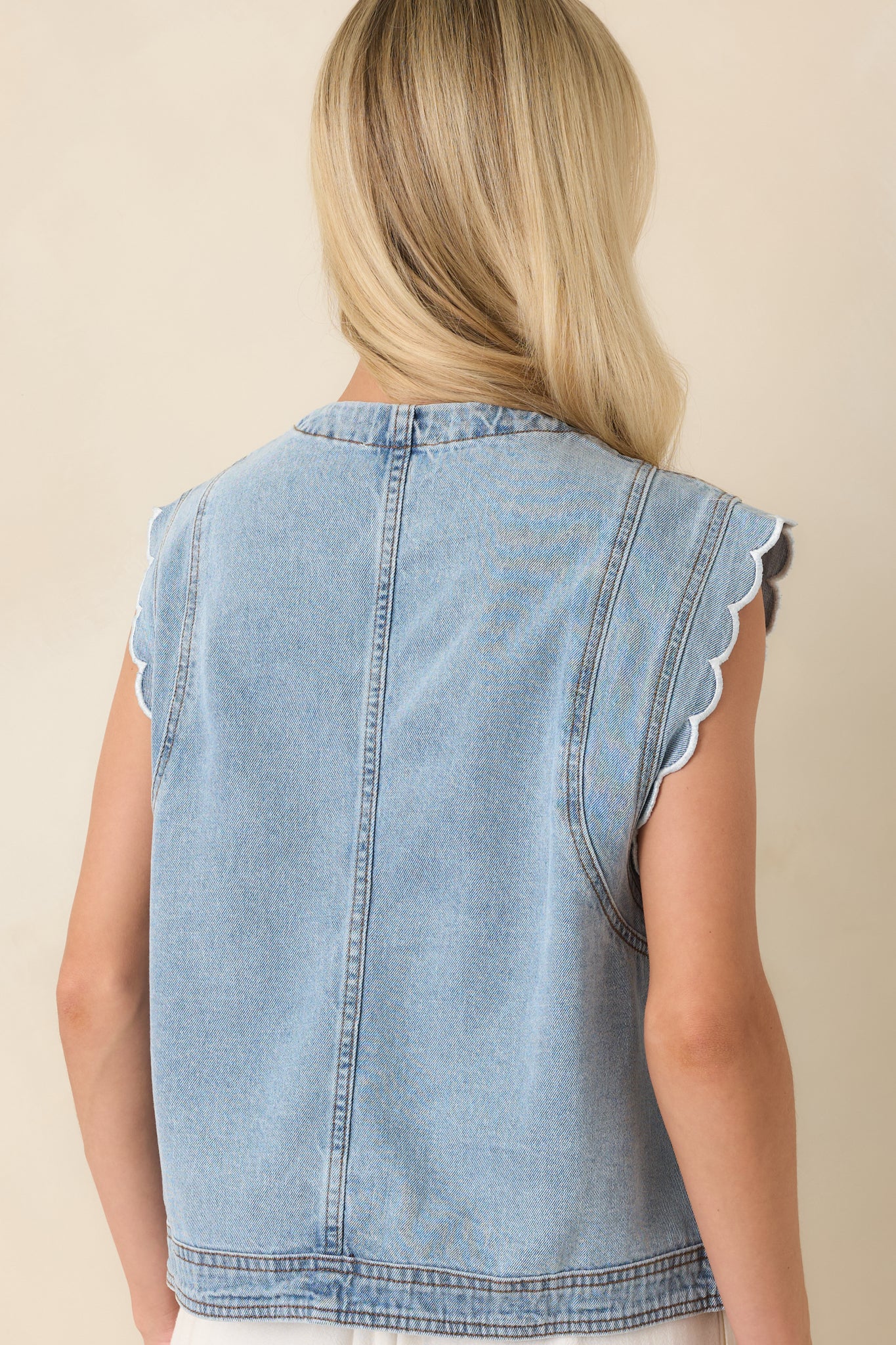 Rear view of the light wash cotton denim vest featuring a clean sleeveless silhouette, rounded neckline, and lightweight denim construction.