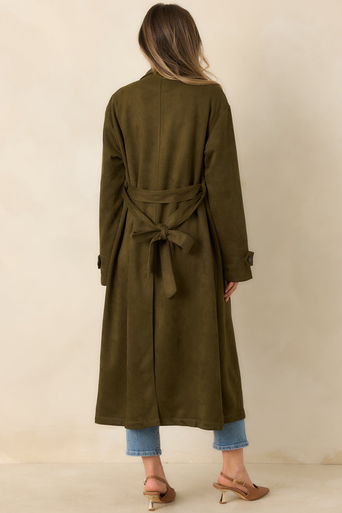Rear view of the longline coat showing its tailored back, long sleeves, and matching waist belt.