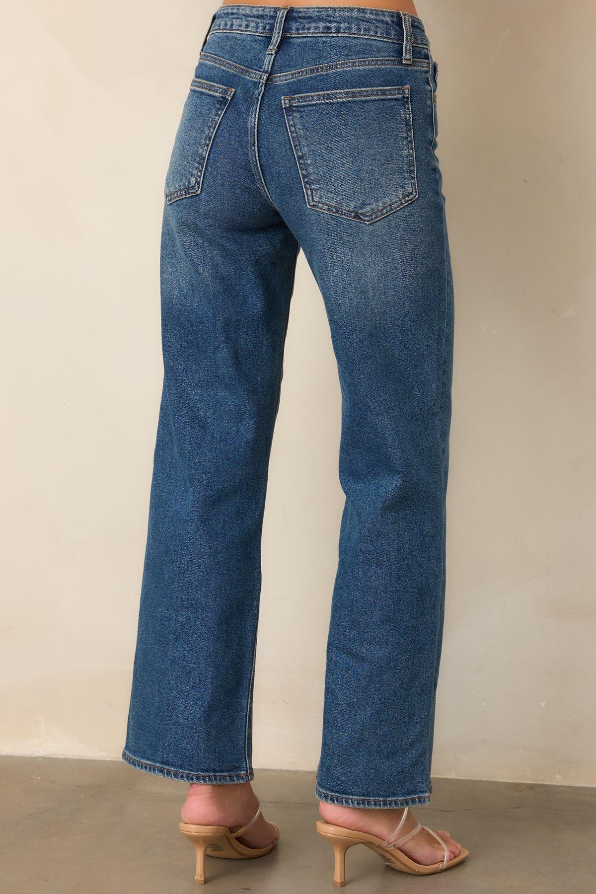 Rear of the medium wash jeans featuring the high-rise waist and classic back pockets.
