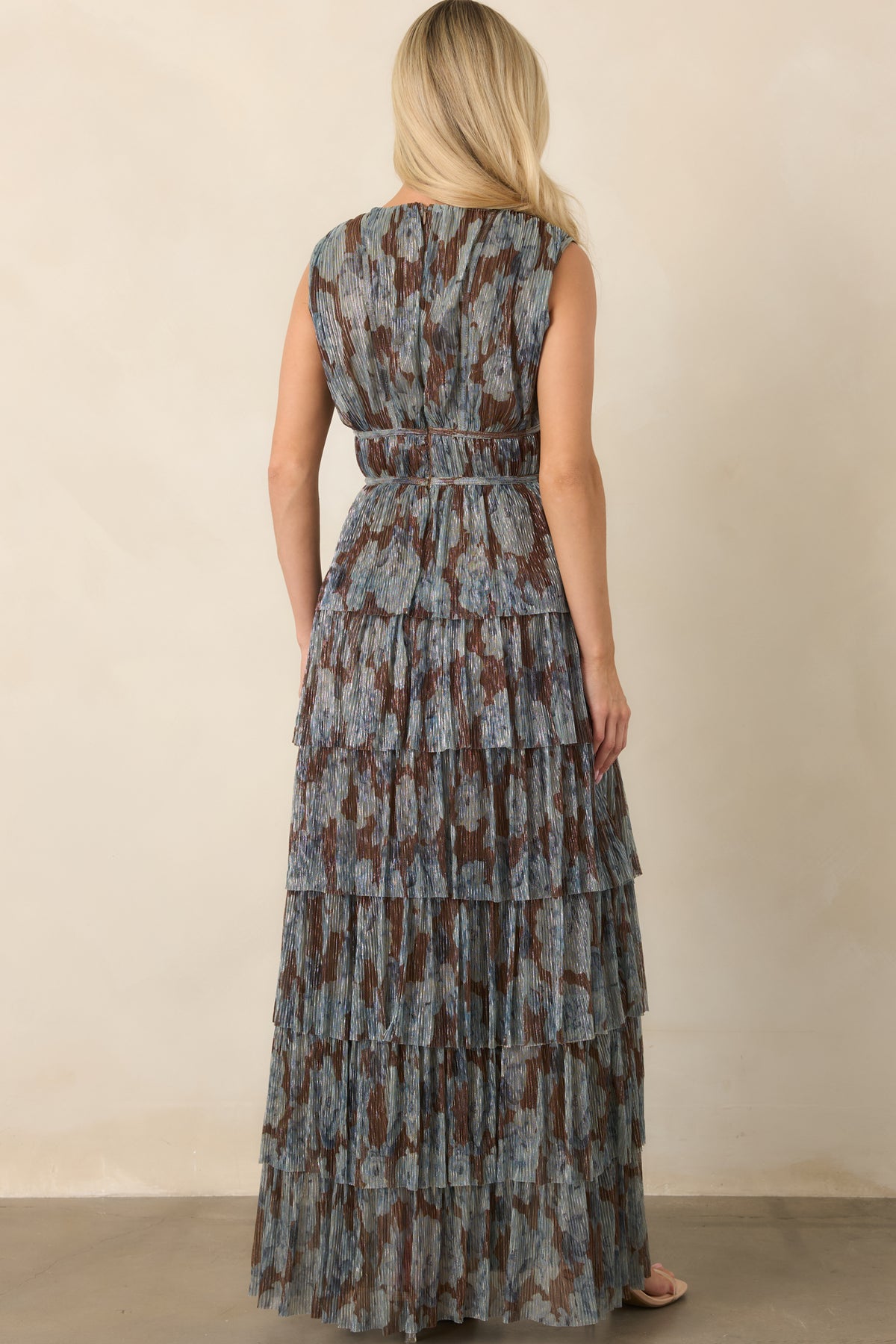 Rear view of the metallic steel blue and chocolate floral dress showing its concealed zipper and cascading floor-length tiers.