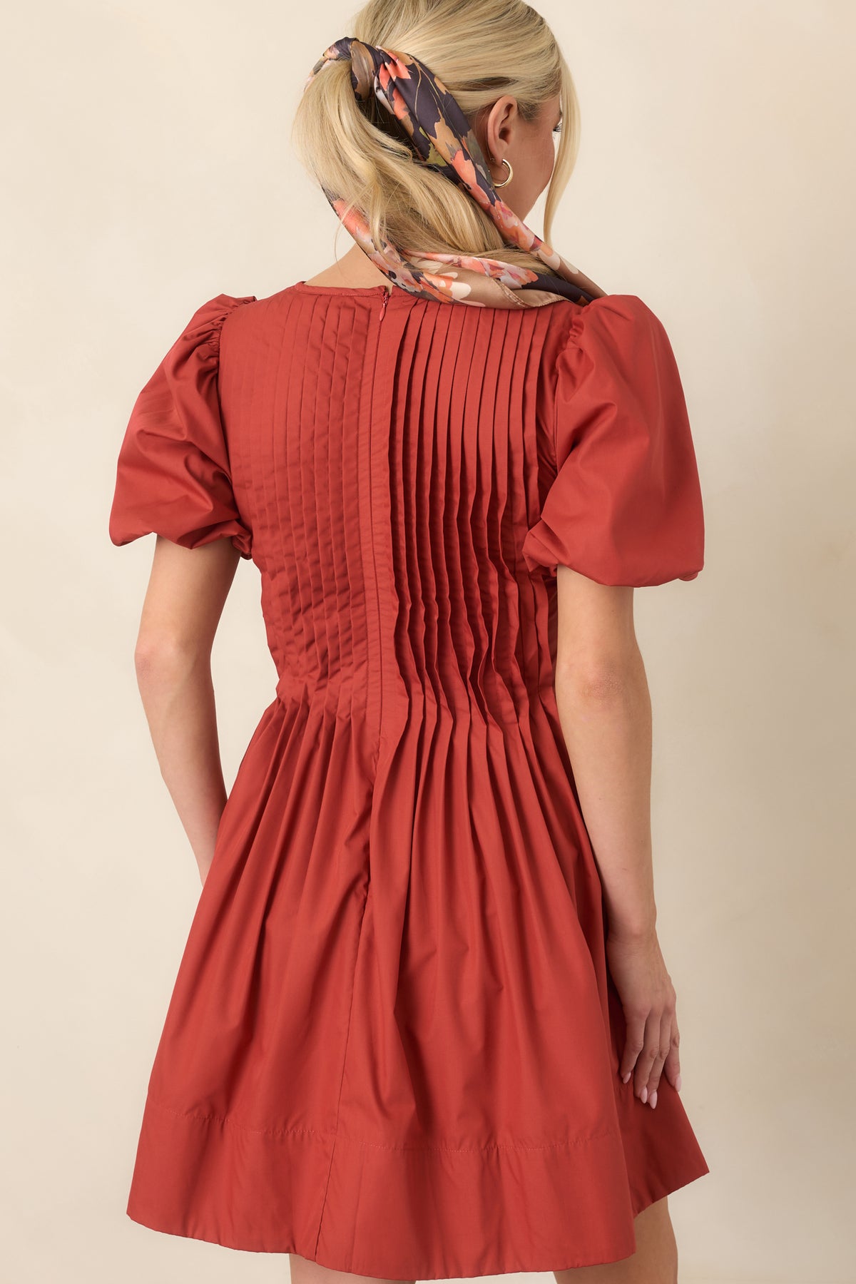 Rear view shows pintucking across the bodice, voluminous short sleeves, and the full softly gathered skirt.
