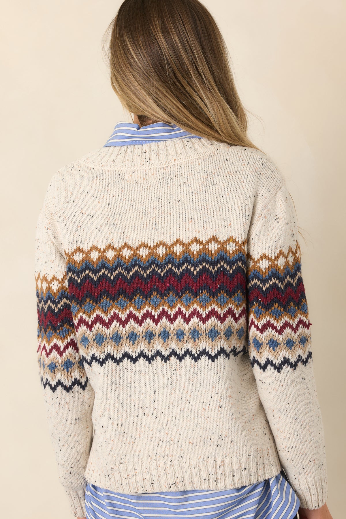 Rear of the natural-hued flecked knit top showing the patterned long sleeves and ribbed hem and cuffs.
